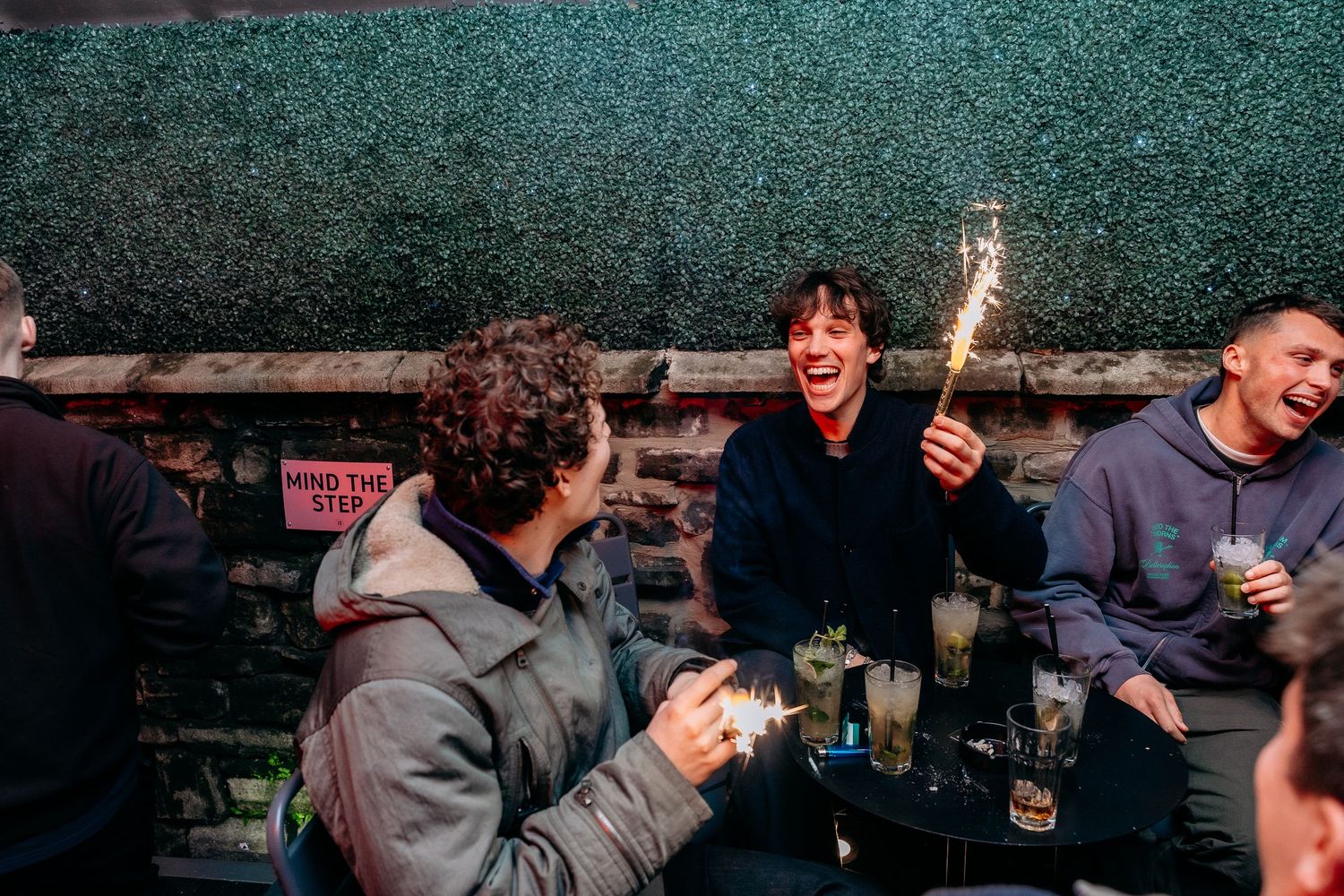People enjoying themselves at a dimly lit indoor gathering or party.