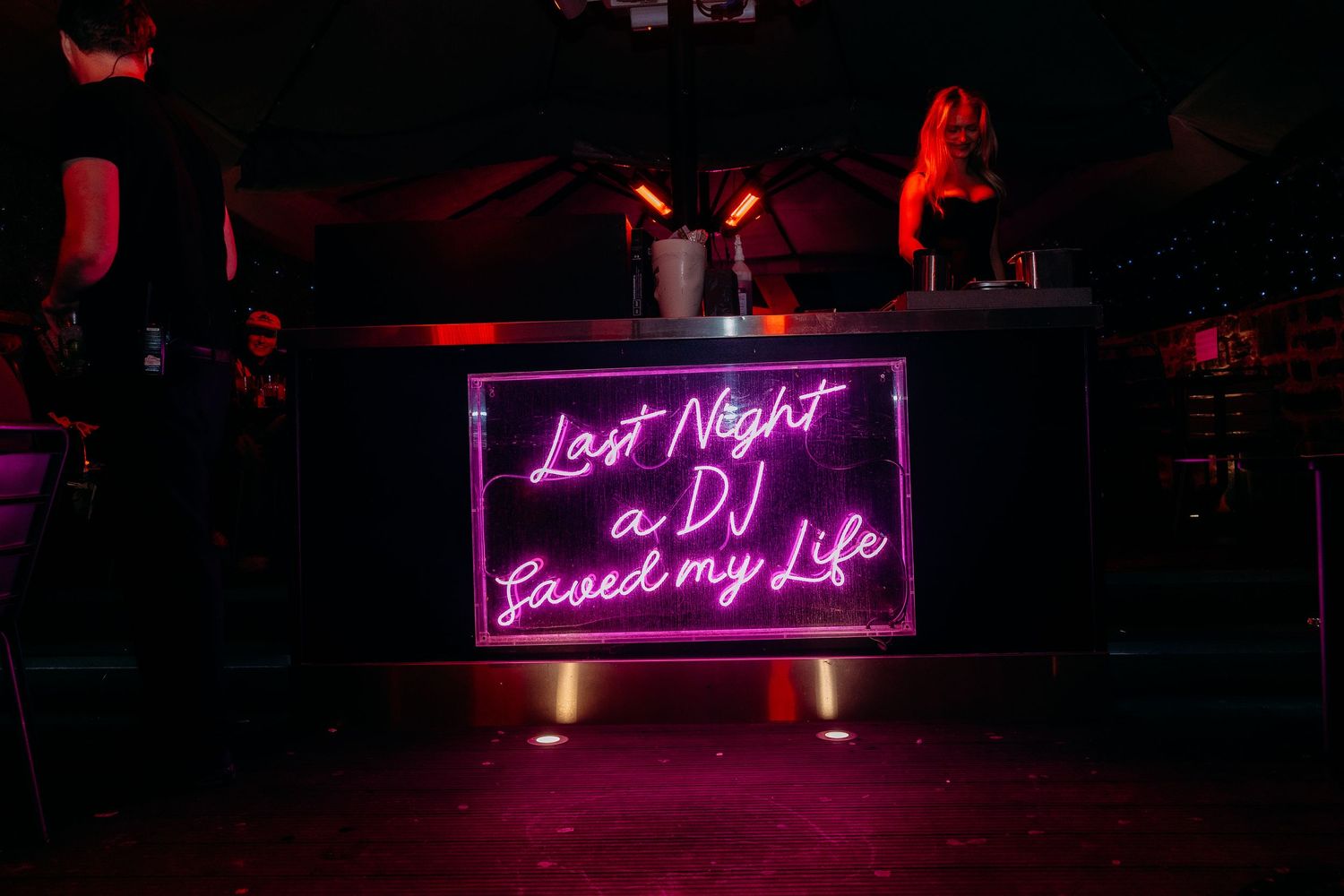 Purple neon signs glowing in the darkness create a moody nighttime atmosphere.