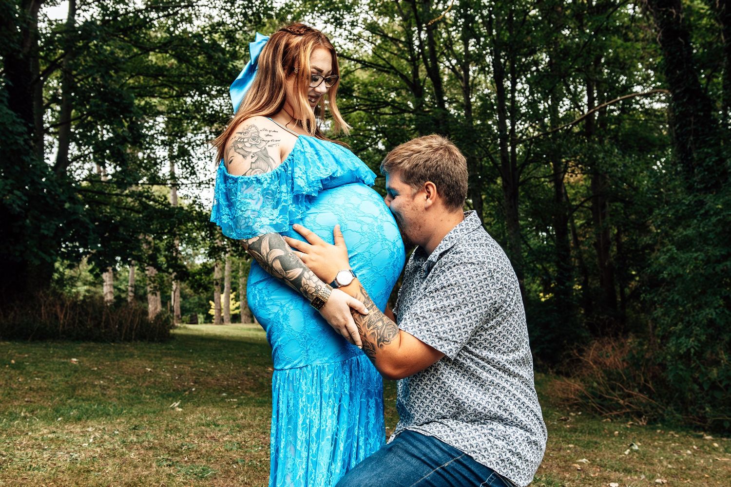 Proposal moment captured in a scenic wooded setting with bright blue dress.