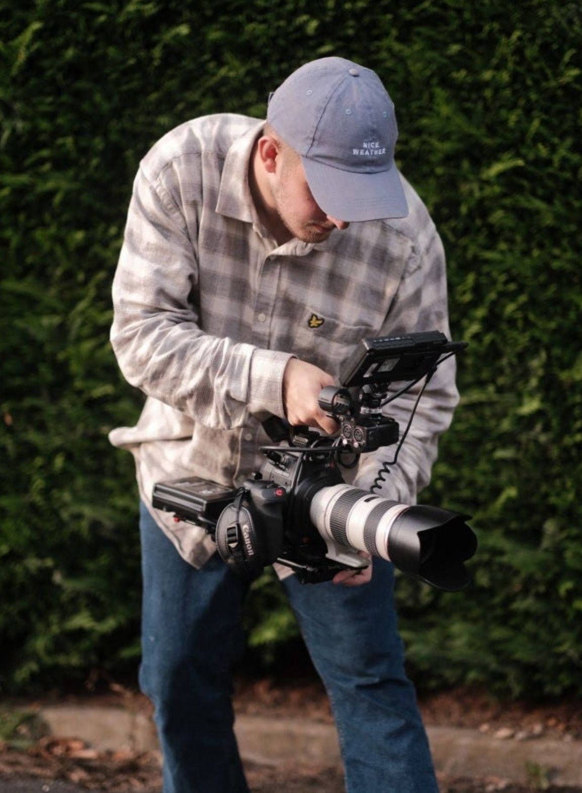 Photographer adjusting camera settings while shooting in outdoor setting.