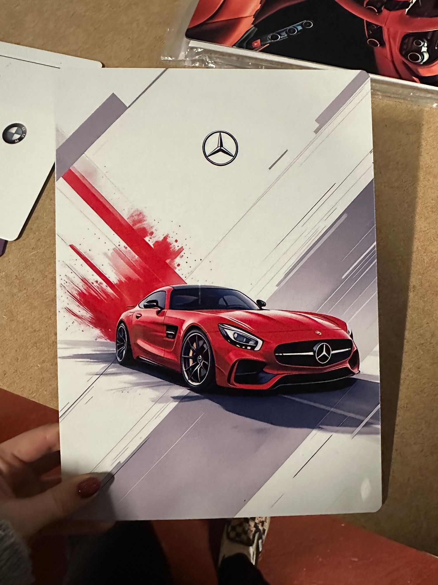 A sequence of artistic illustrations showing a red Mercedes-Benz AMG GT sports car being drawn in progressive stages.