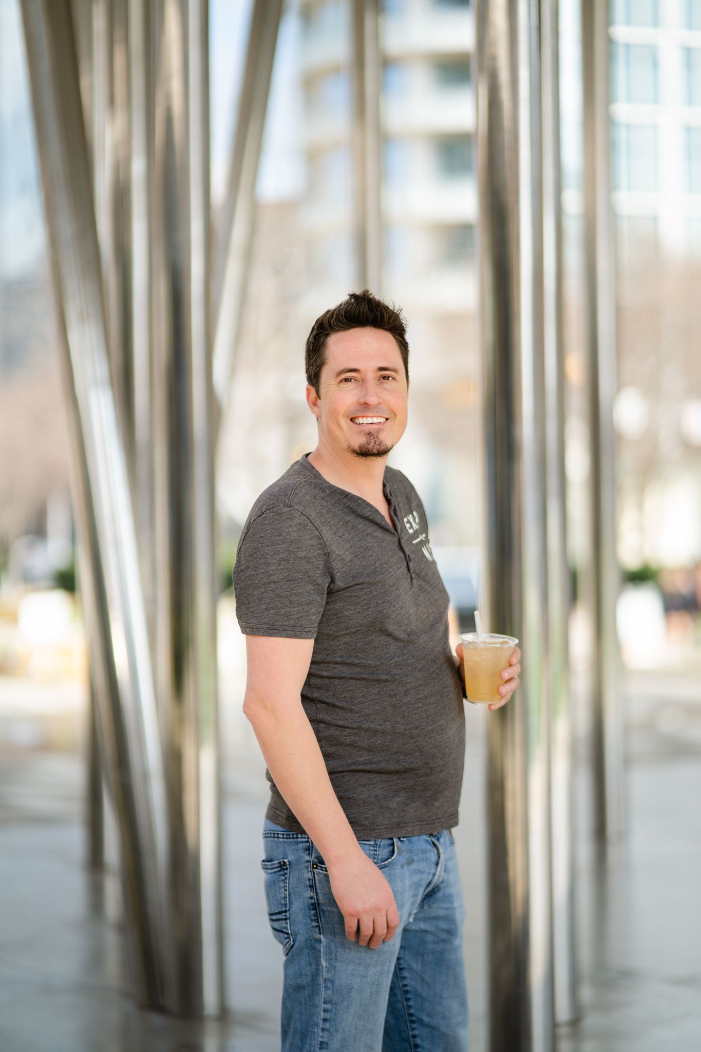 Casual studio portraits showing a person wearing a grey t-shirt and jeans against a light background.