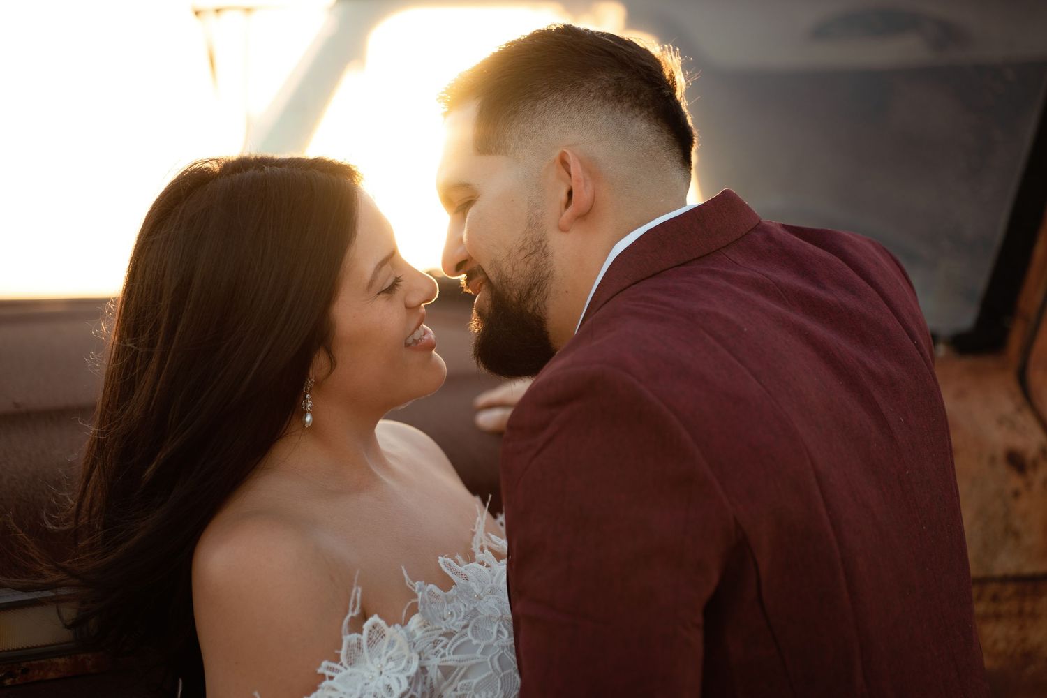 A romantic couple in formal attire sharing a tender kiss during their wedding celebration.