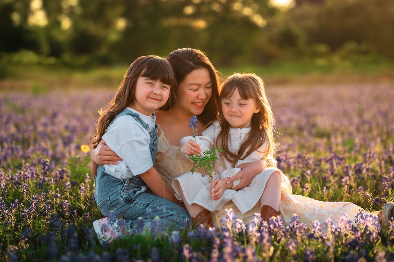 A group sits together in a blooming purple wildflower field during golden hour sunset.