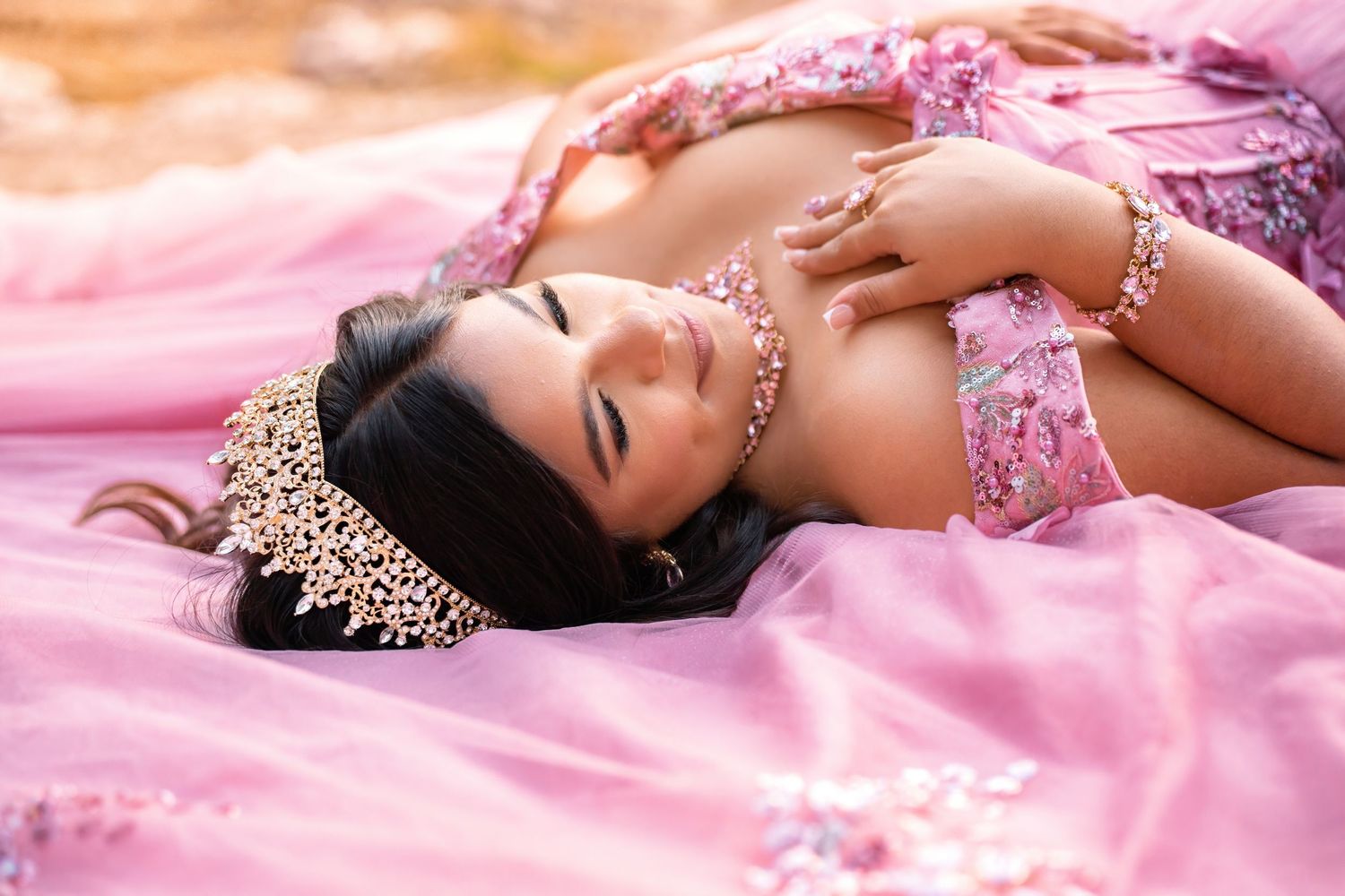 Dreamy pink boudoir photography composition featuring soft lighting and delicate bridal accessories on tulle fabric.