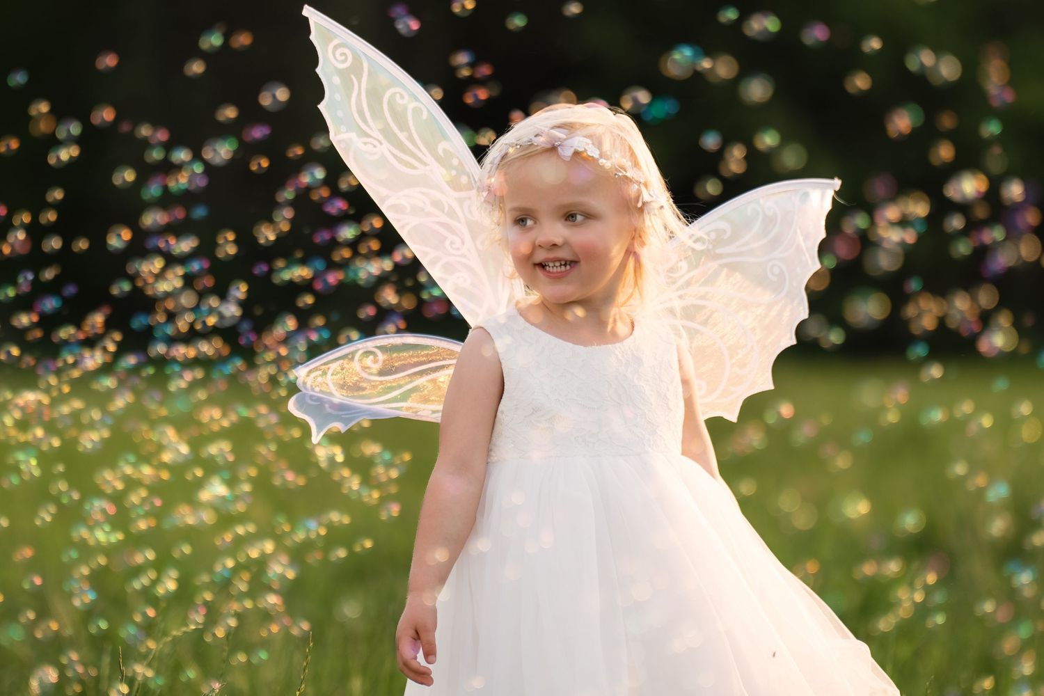 A young figure in a white fairy costume with wings twirls joyfully in a garden as autumn leaves fall around them.