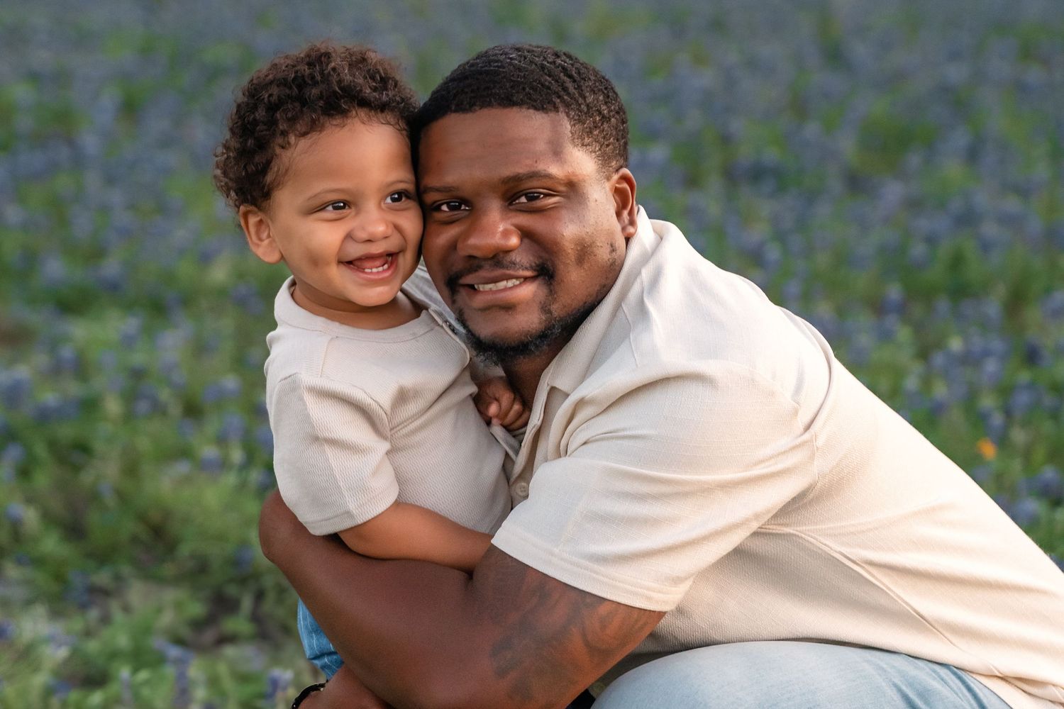 A joyful moment shared between parent and child while sitting among blooming bluebonnets in a spring field.