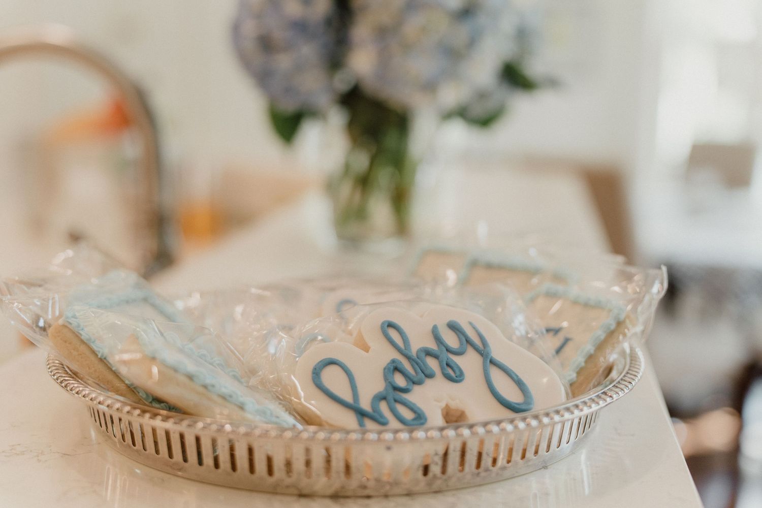 Close up of blue lettered handwriting on a small round coaster with a decorative scalloped edge.
