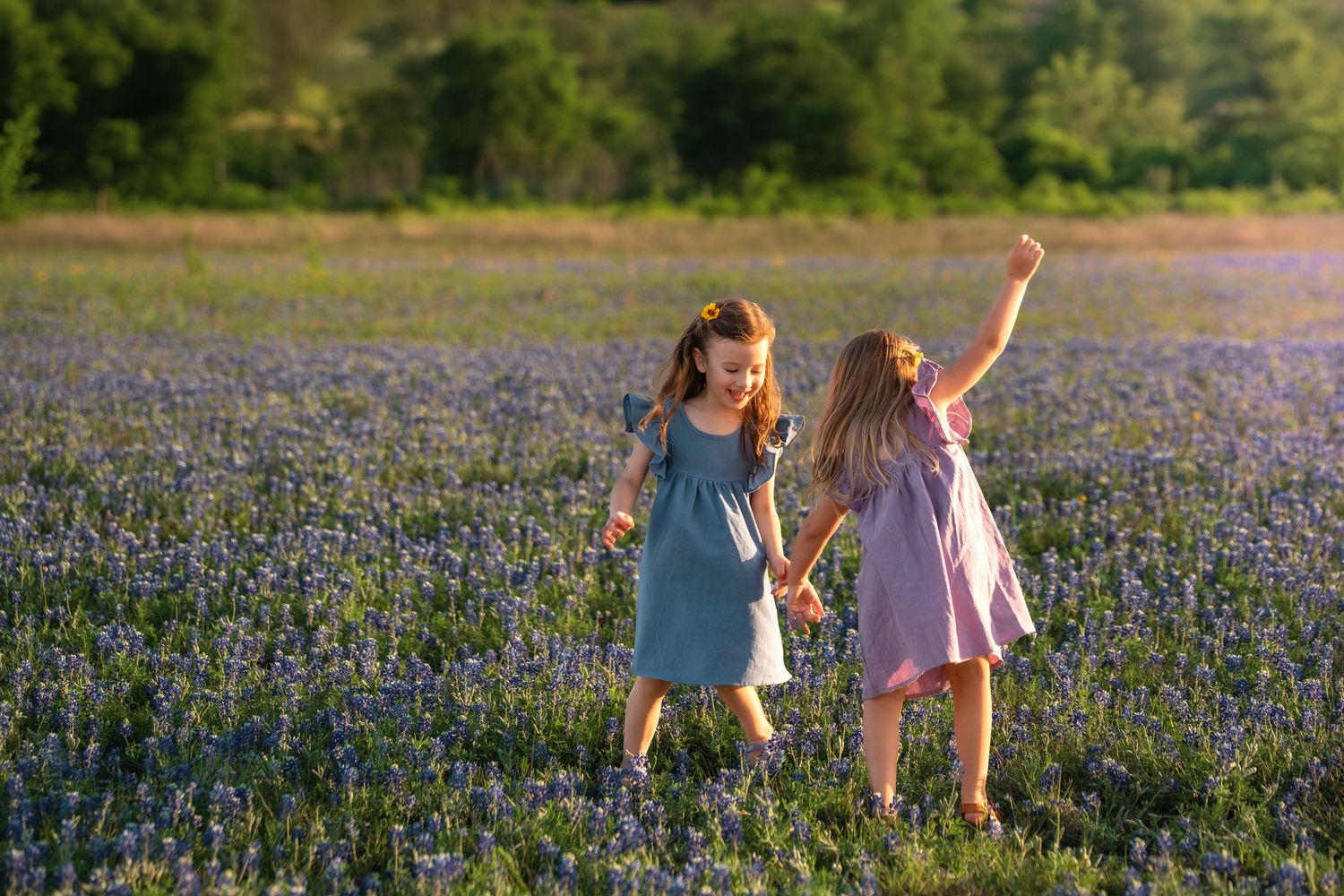 Two people walking through a vibrant field of blooming bluebonnets in Texas during springtime.