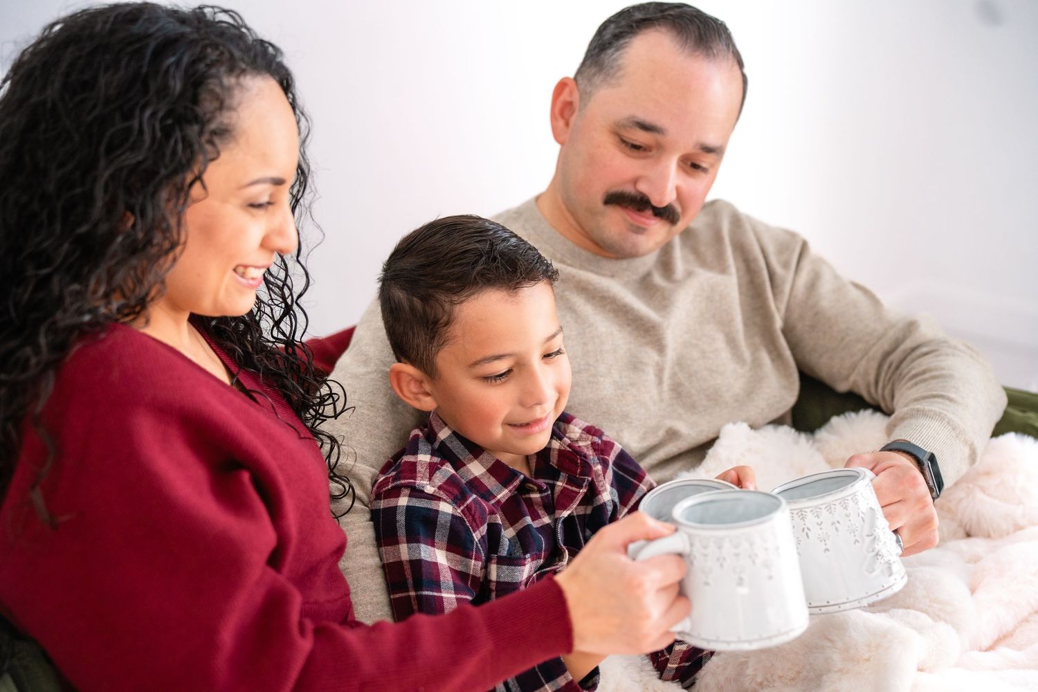 A relaxed family moment together with warm drinks in their matching holiday outfits.