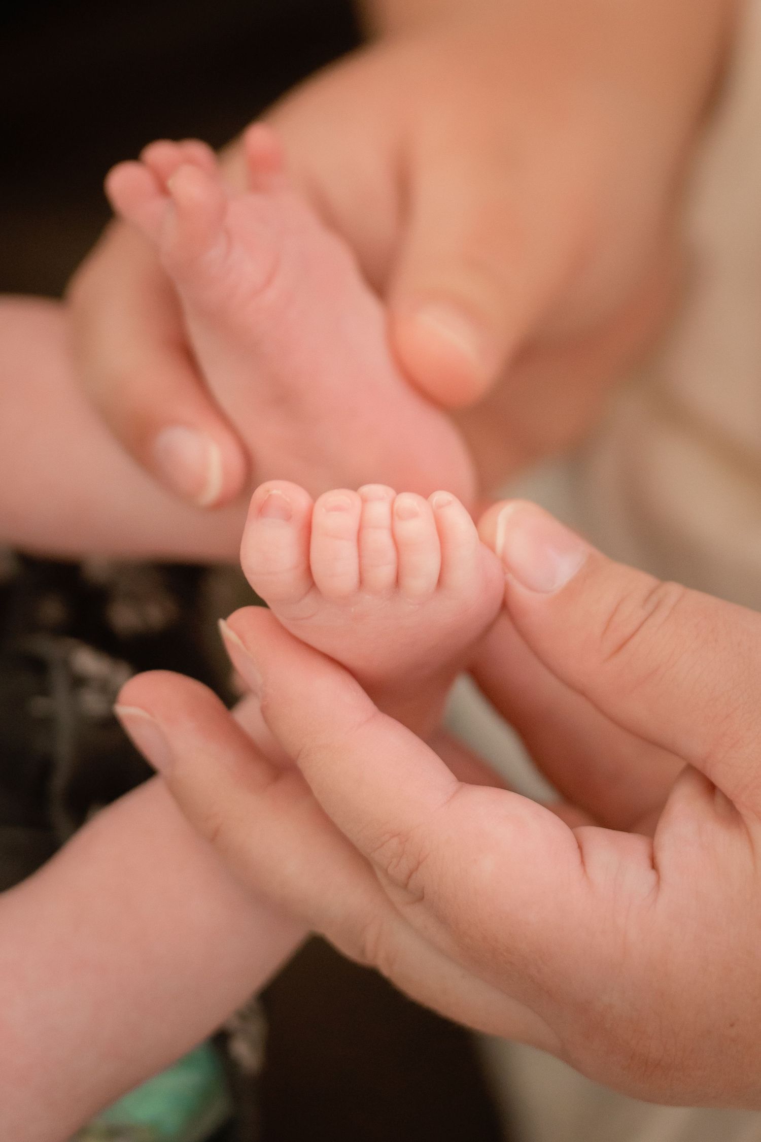 A close-up series of gentle hands massaging a tiny baby's feet showing infant reflexology techniques.