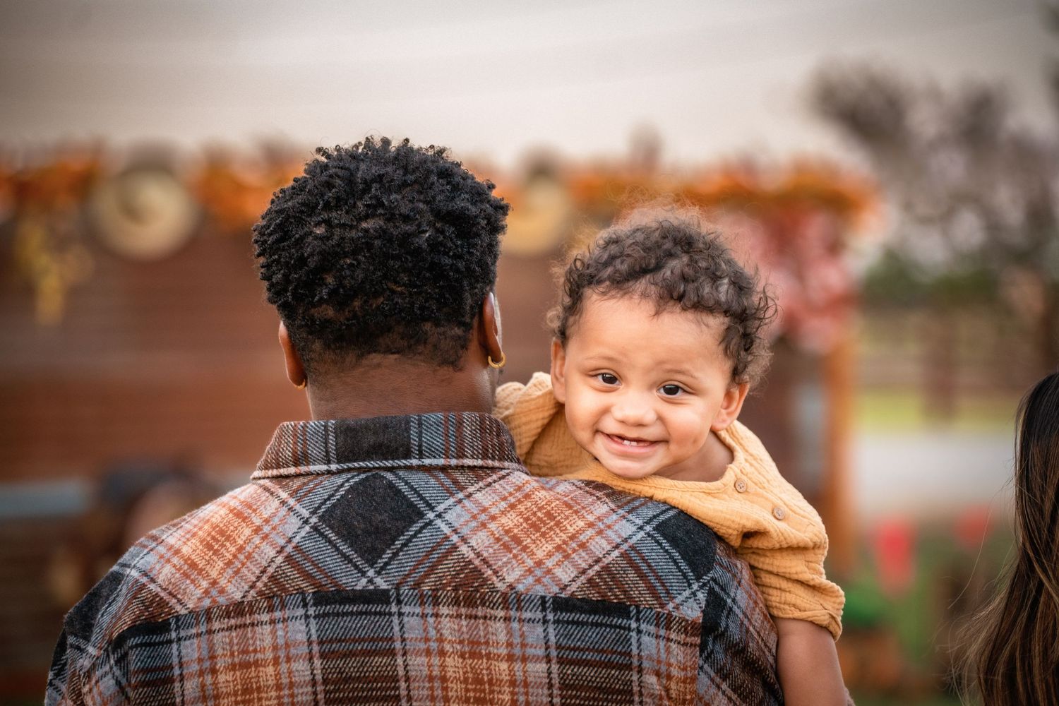 A set of warm-toned outdoor candid photos showing playful family moments and embraces on an autumn day.