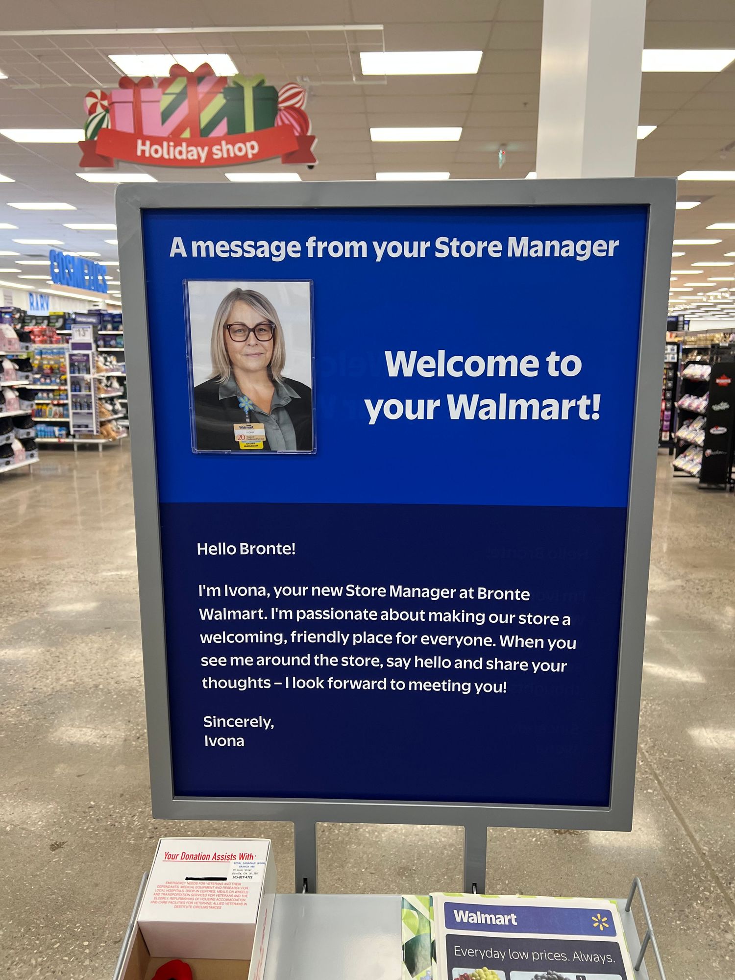 Digital welcome sign display at Walmart store entrance showing manager message and store information.