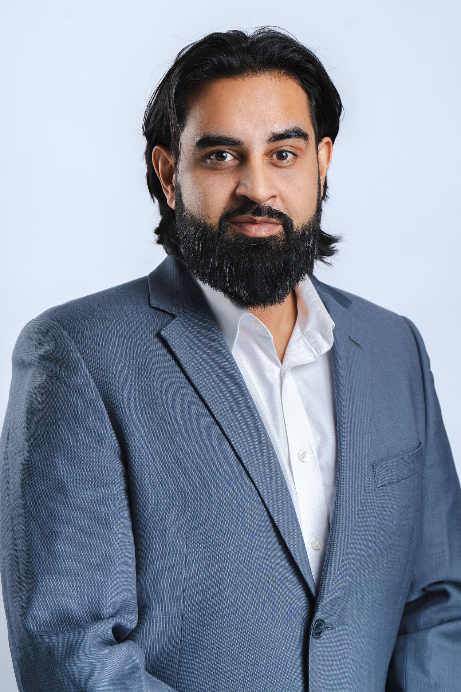 Professional headshots showing a man in a gray suit and white shirt against light background from different angles.