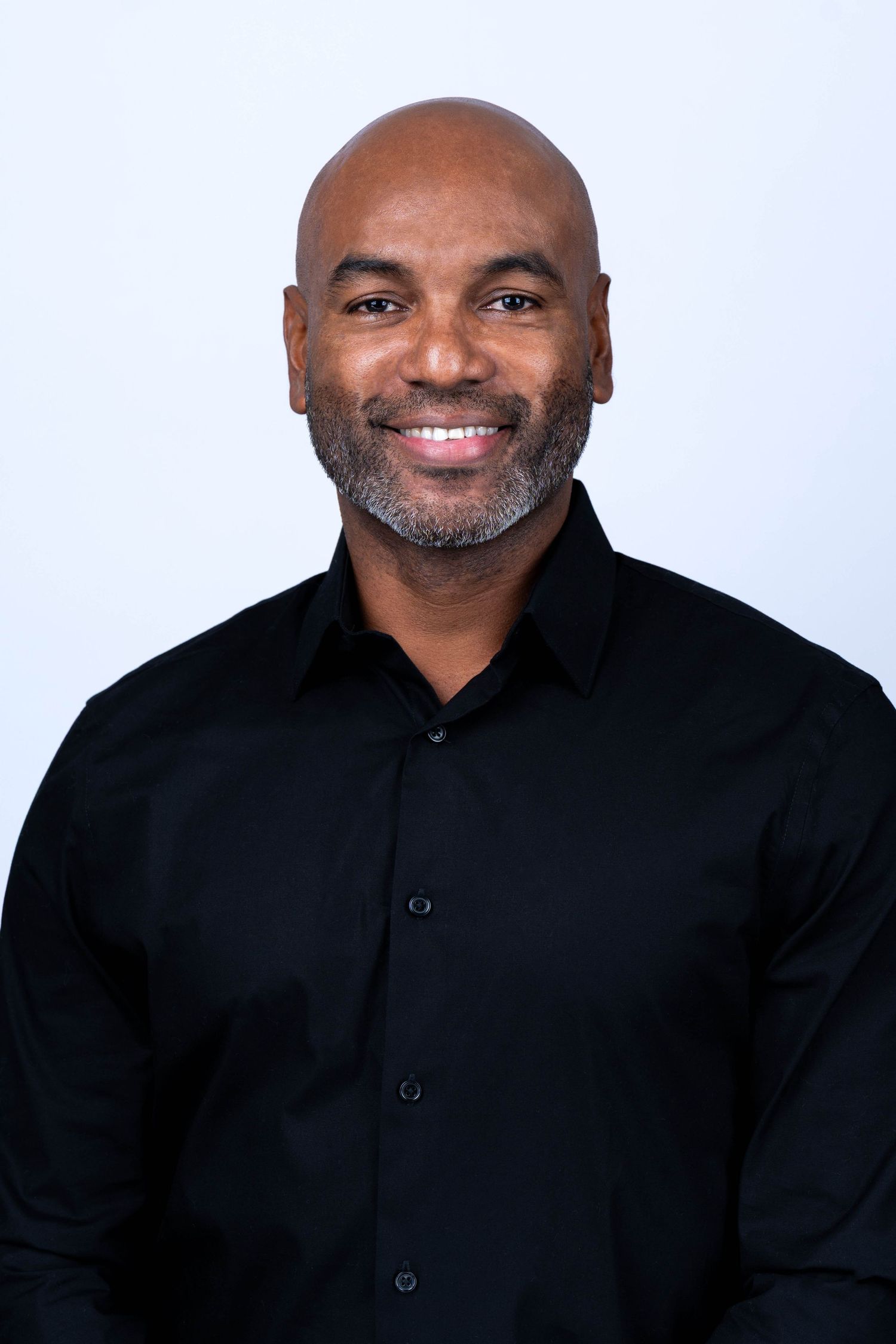 Professional headshot series of a person wearing a black button-down shirt against a white background.