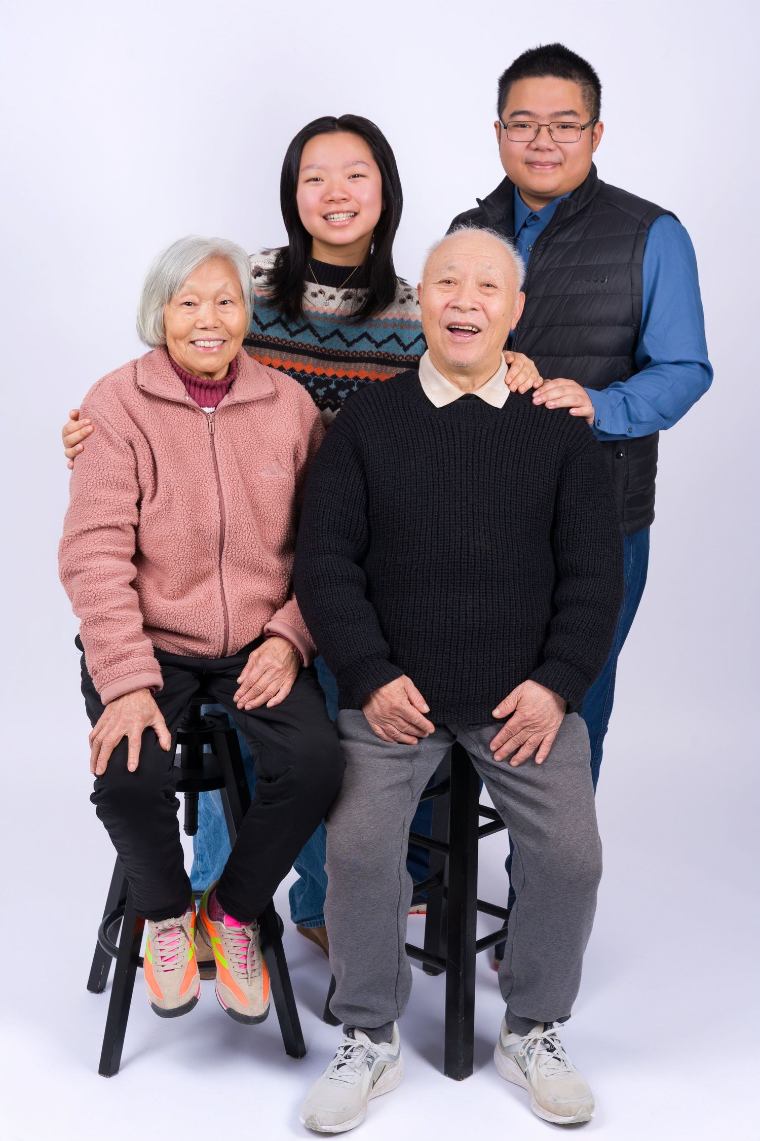 Multi-generational family portrait in casual attire against a white studio background.