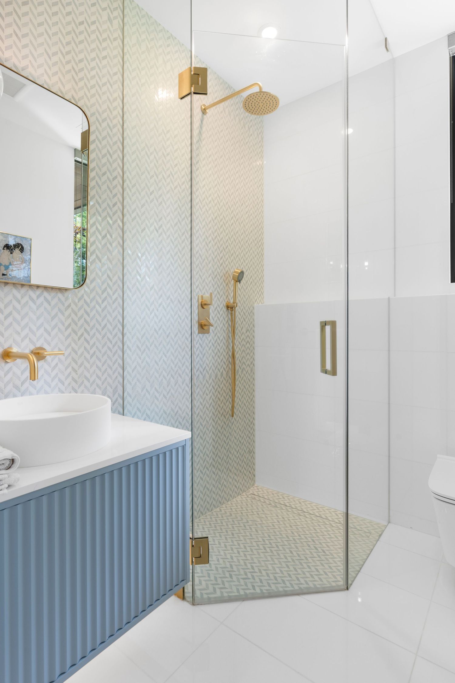 Contemporary bathroom featuring chevron pattern walls and blue wainscoting with gold accents.