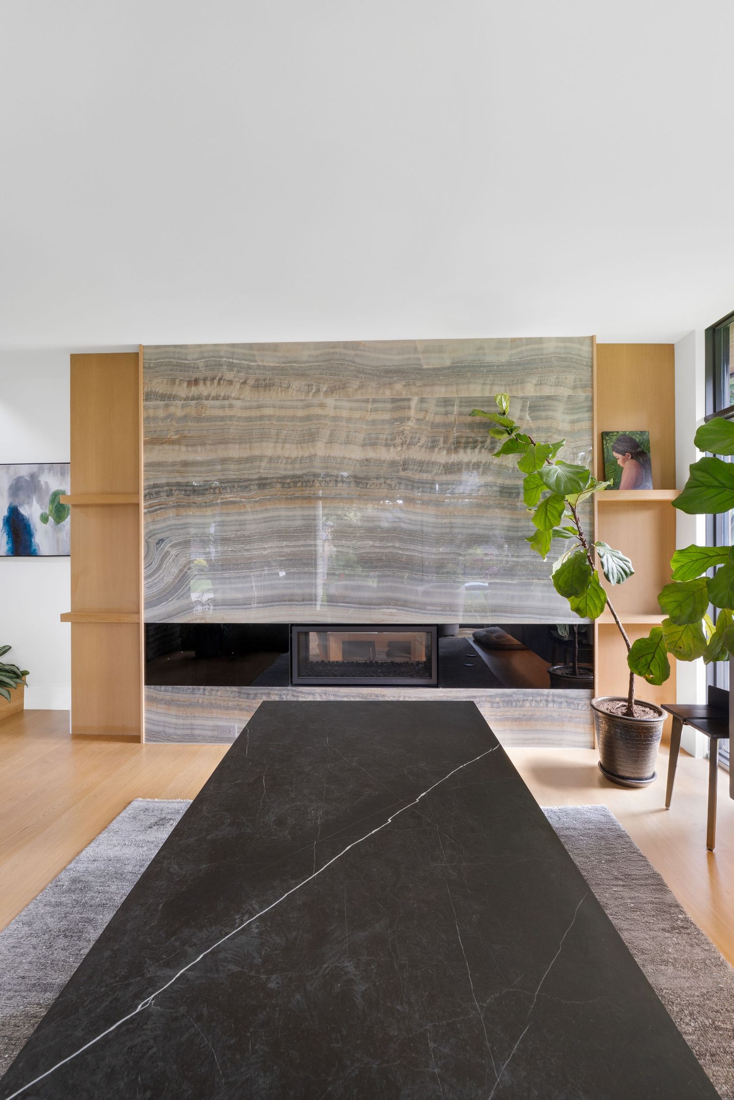Dramatic black marble fireplace feature wall with horizontal striations in a contemporary living space.
