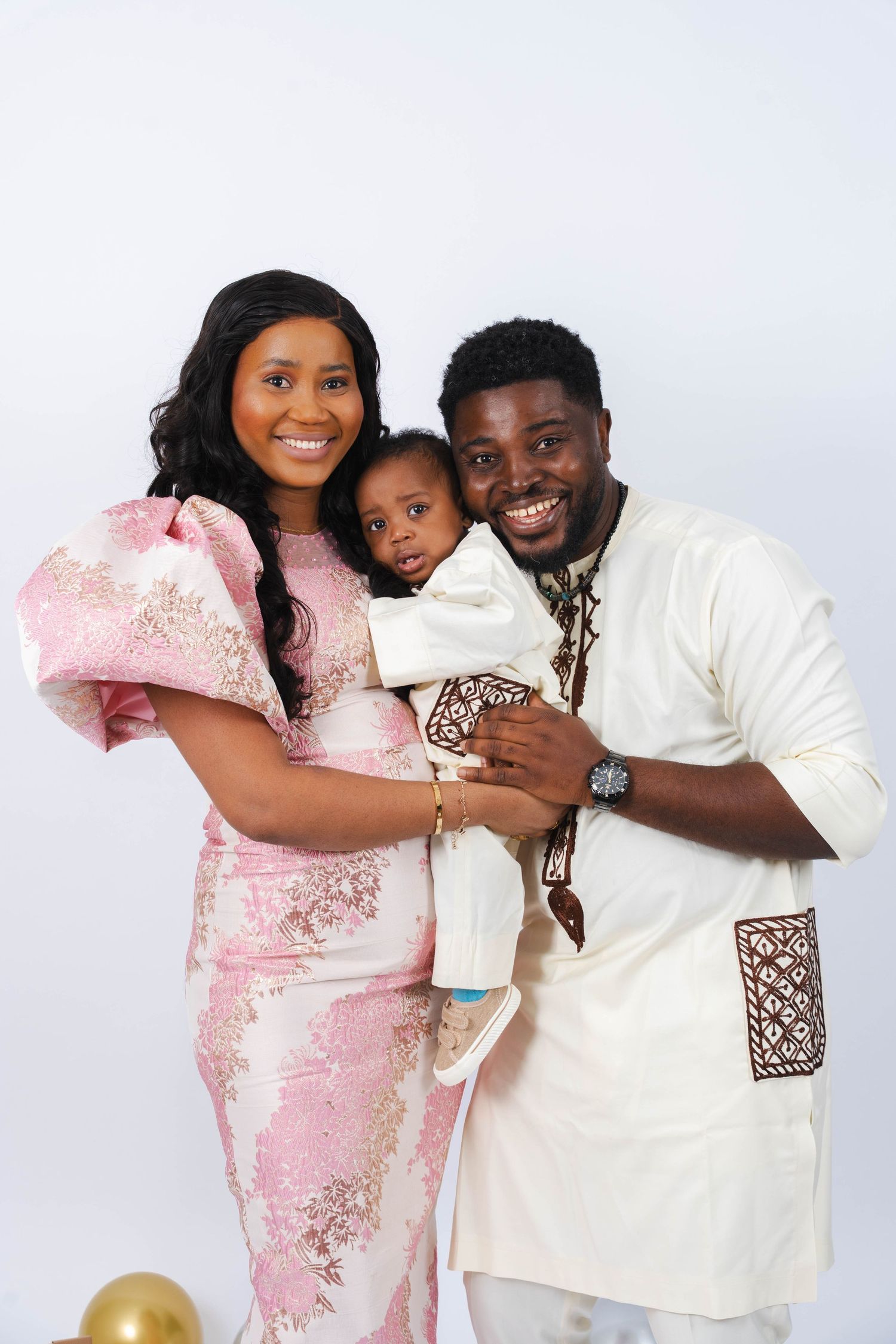 A couple in coordinated pink and white outfits pose together against a light background in a series of loving photos.