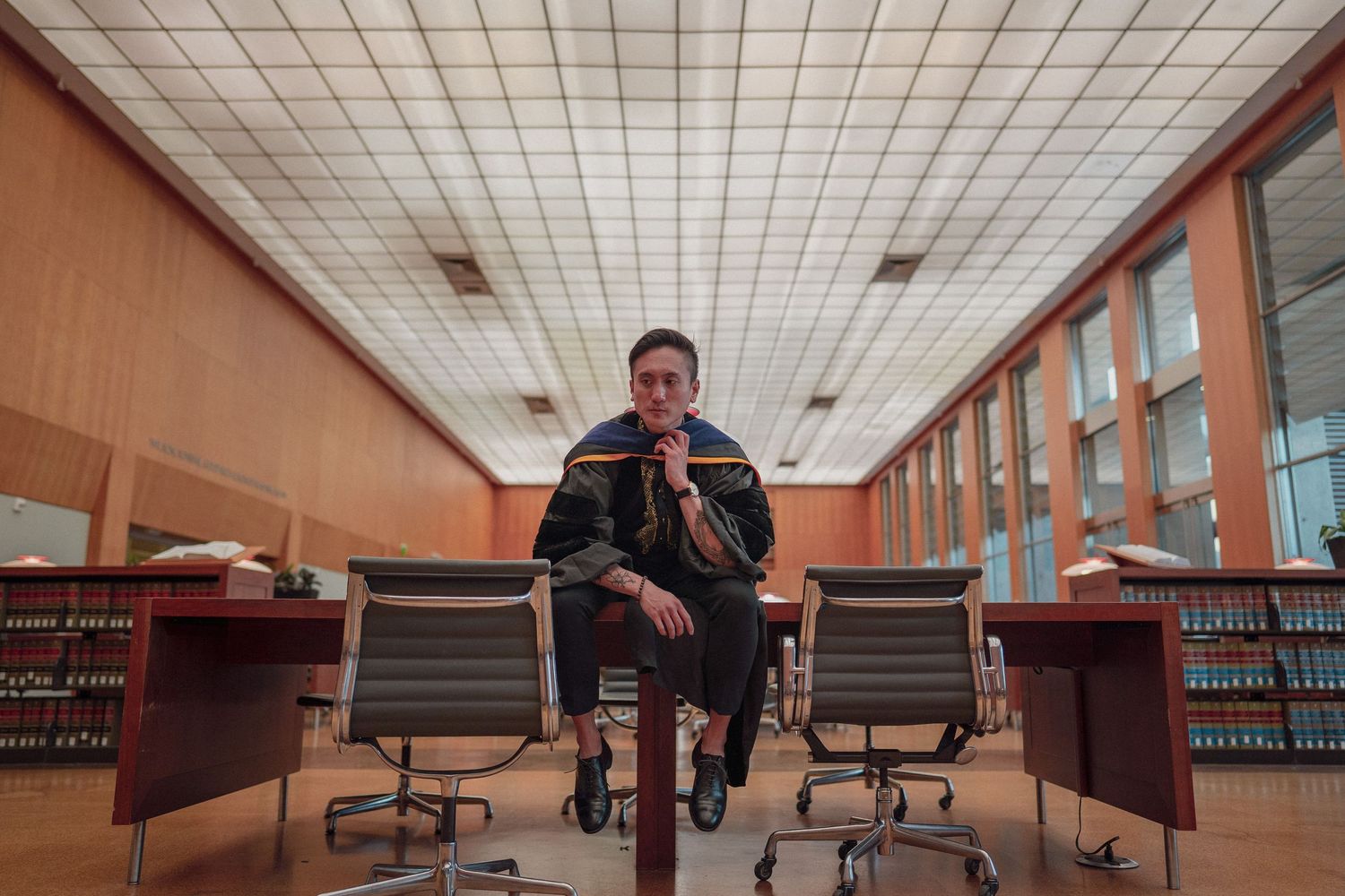 man sitting down on a table, looking ahead for a graduation photo