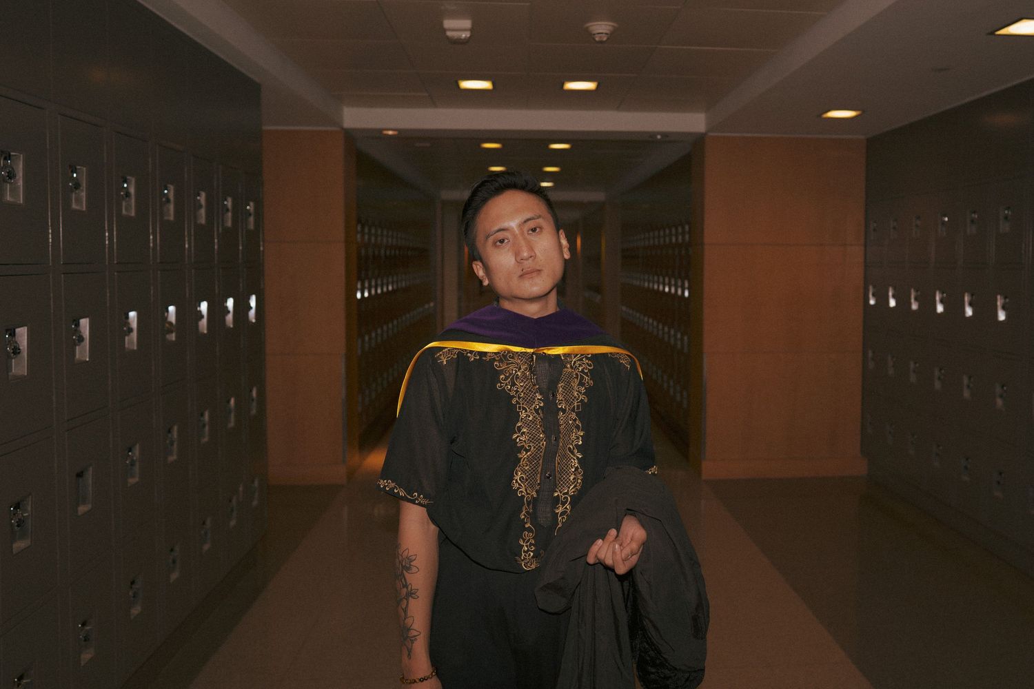 man in a hallway wearing tradiotional filipino attire posing for a graduation photo