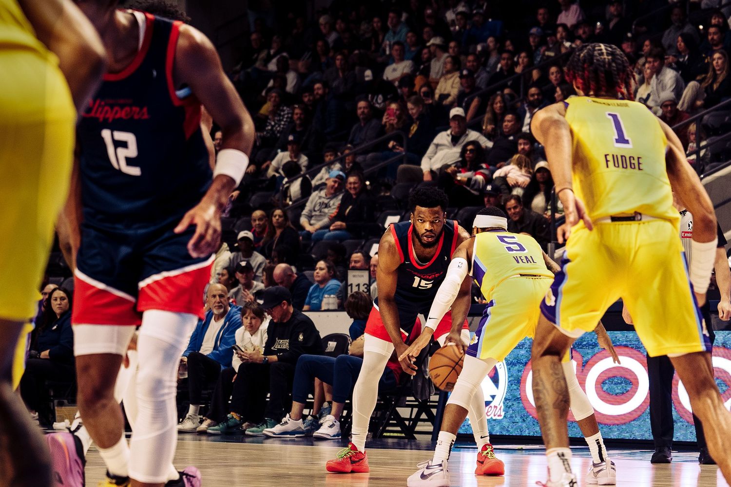 Basketball players in red and yellow jerseys compete during an intense NBA game on the court.