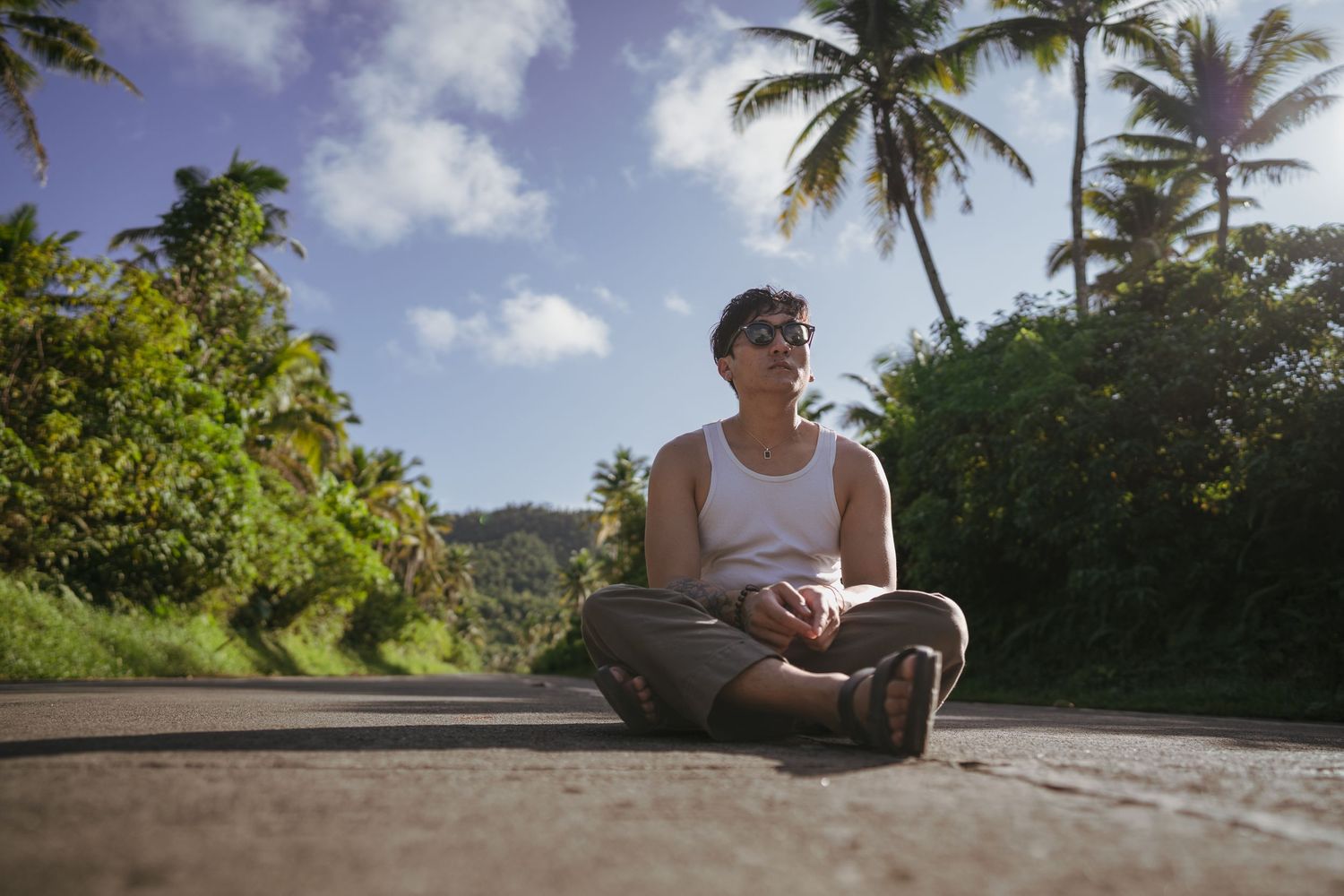 photo of a Filipino man sitting in the middle of Coconut Road in Siargao.