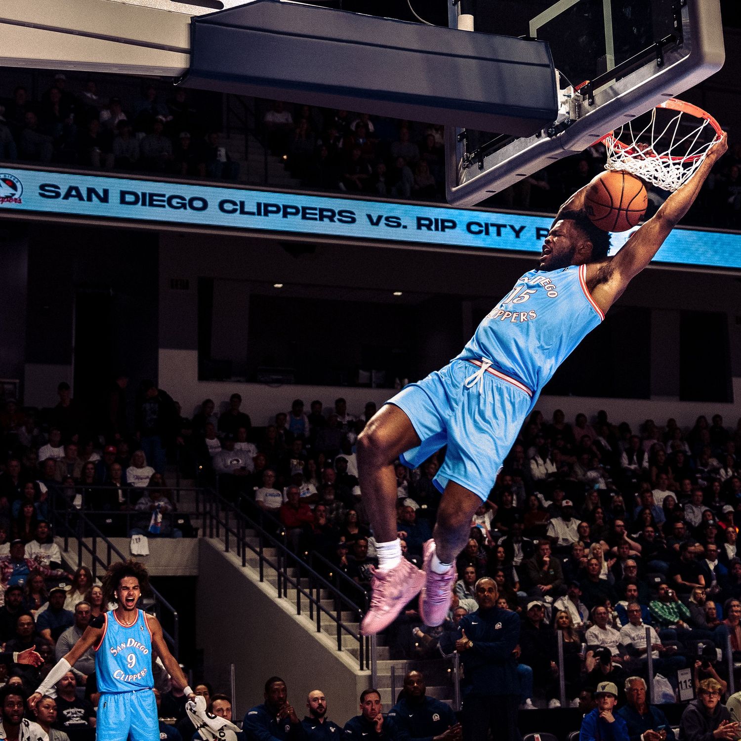 NBA player soars through the air for a powerful slam dunk during a basketball game against the San Diego team.