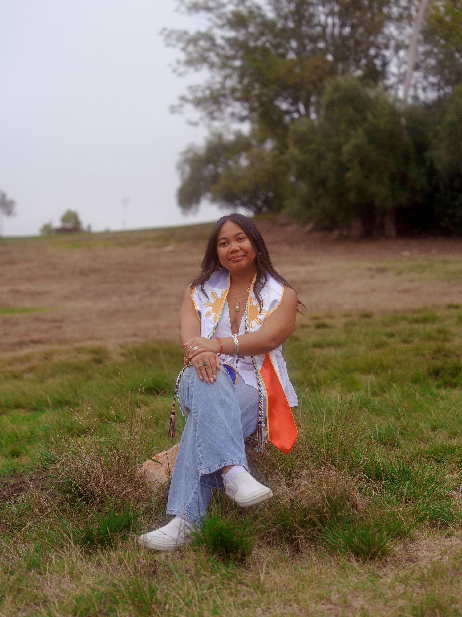 girl sitting down with a filipino stole posing for a graduation photo