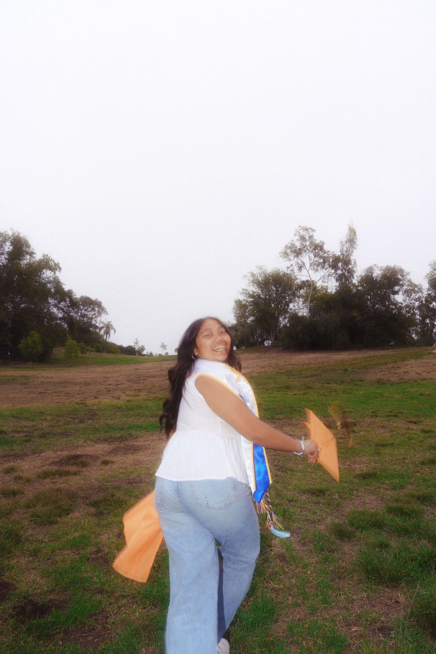 playful graduation photo of a girl runnning