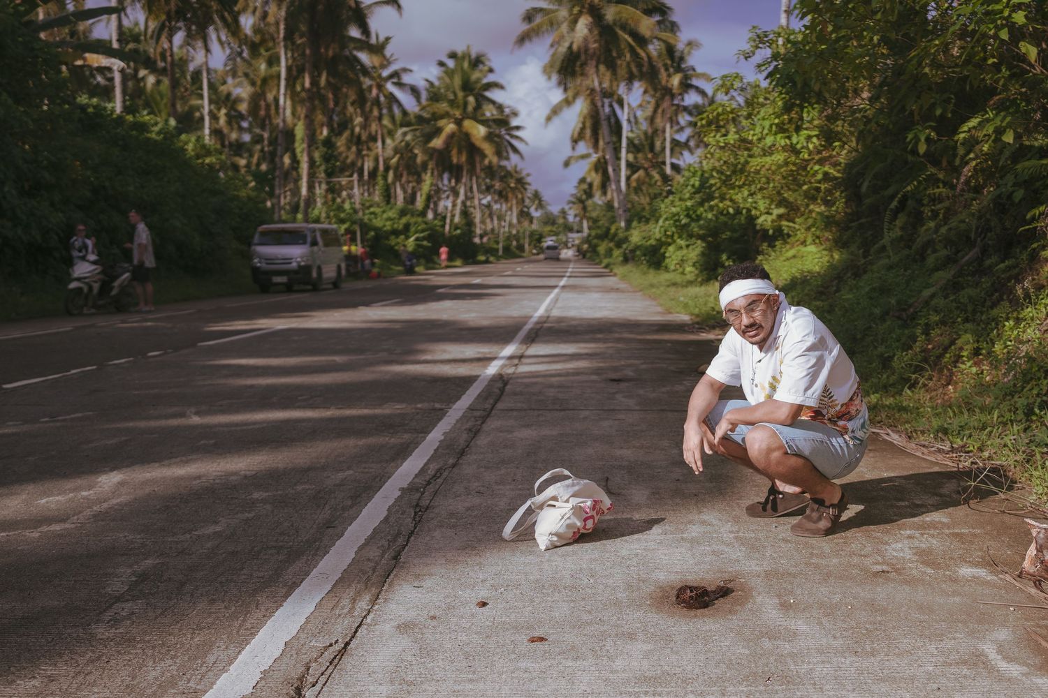 man on coconut road squatting