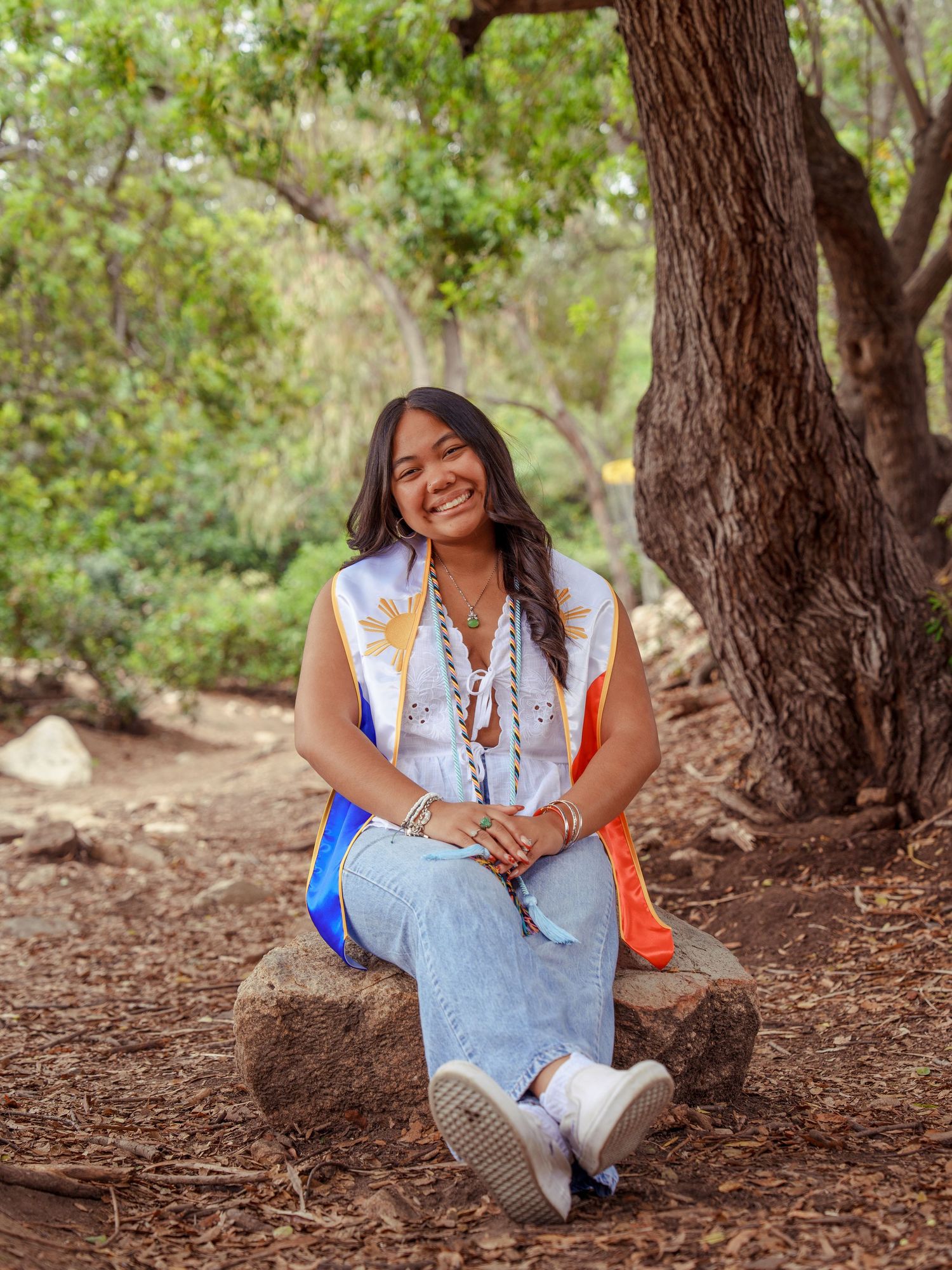 girl sitting down with a filipino stole posing for a graduation photo