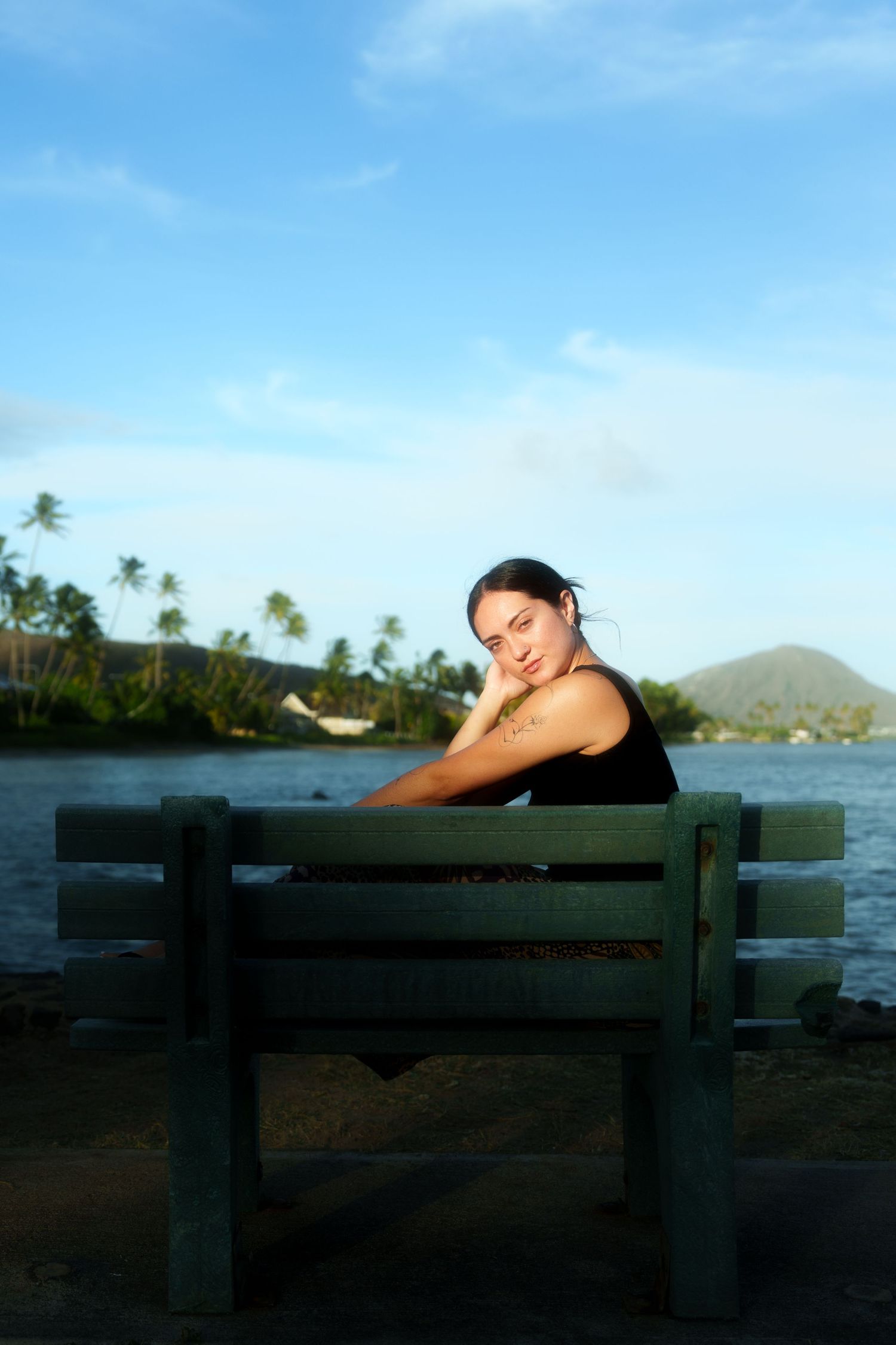 Girl in Hawaii, sitting on a bench during the Sunset.