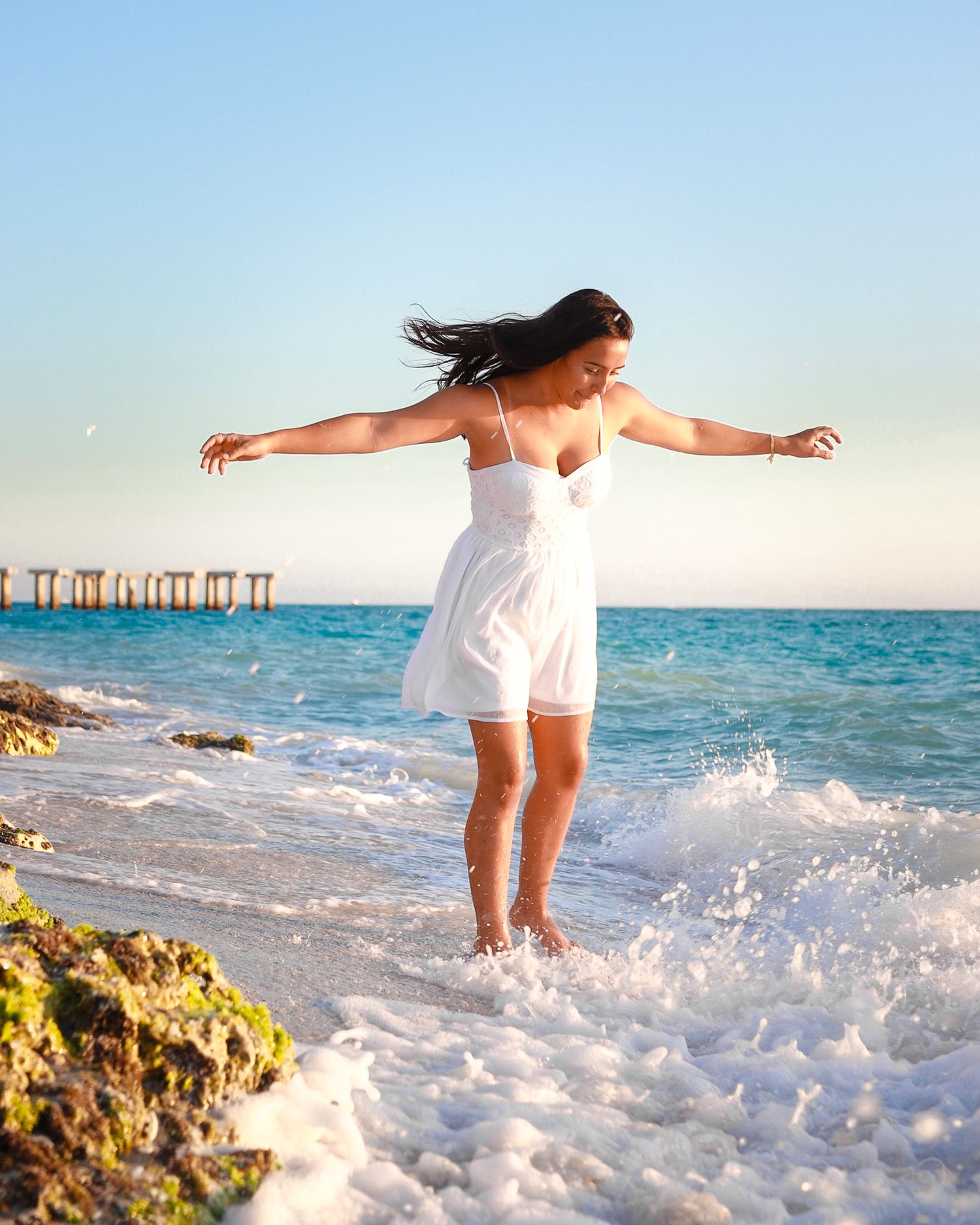A girl playing in the waves on the beach