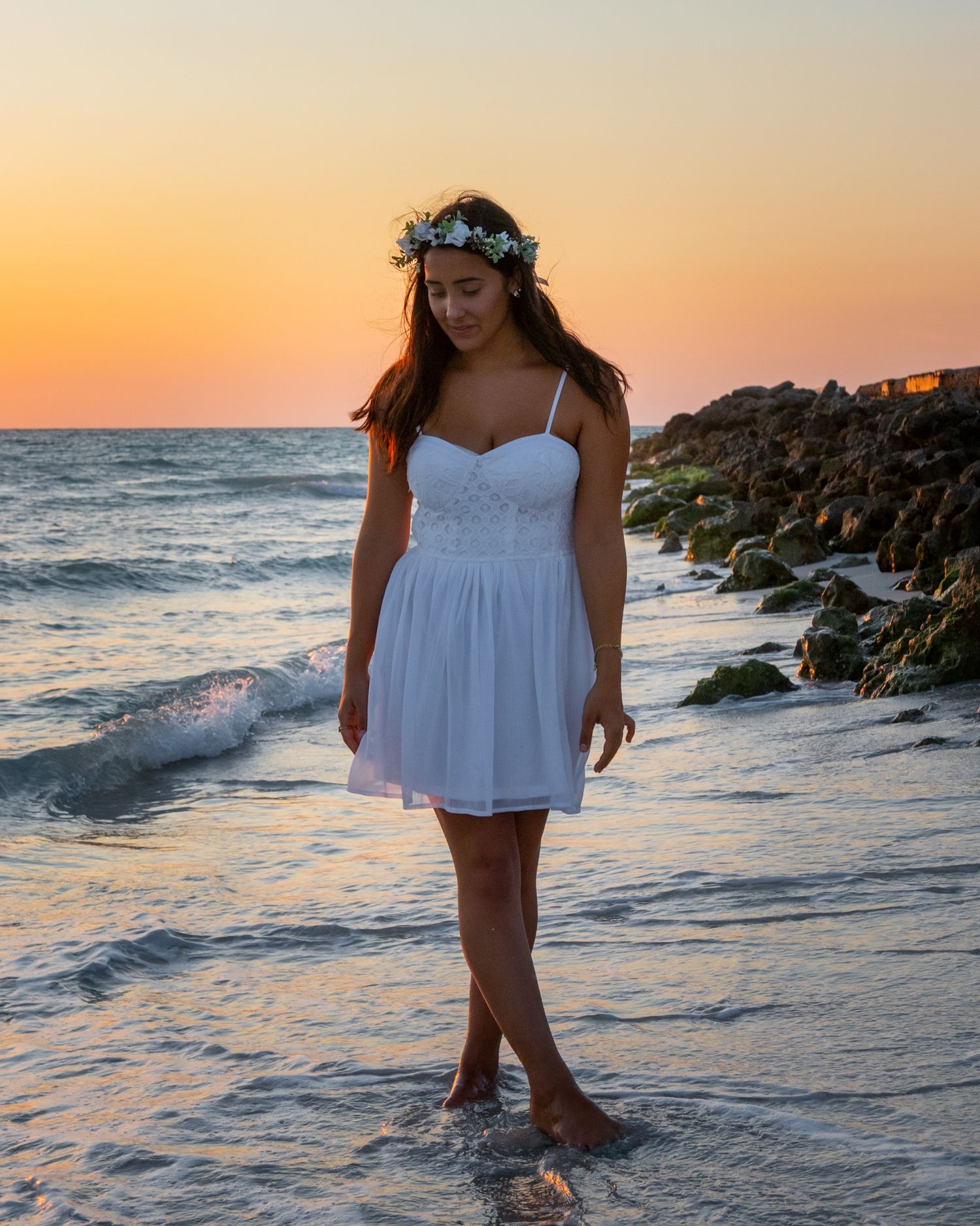 Girl standing on the beach at sunset