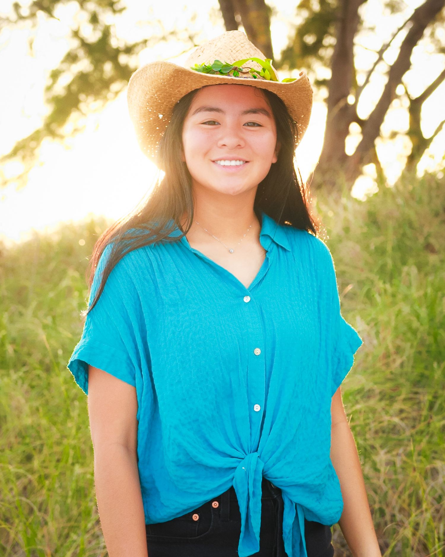 A girl wearing a costal cowgirl hat smiling for the camera