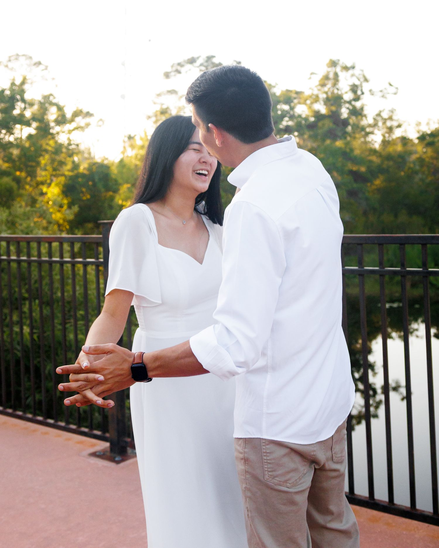 A couple smiling and laughing at each other while holding hands
