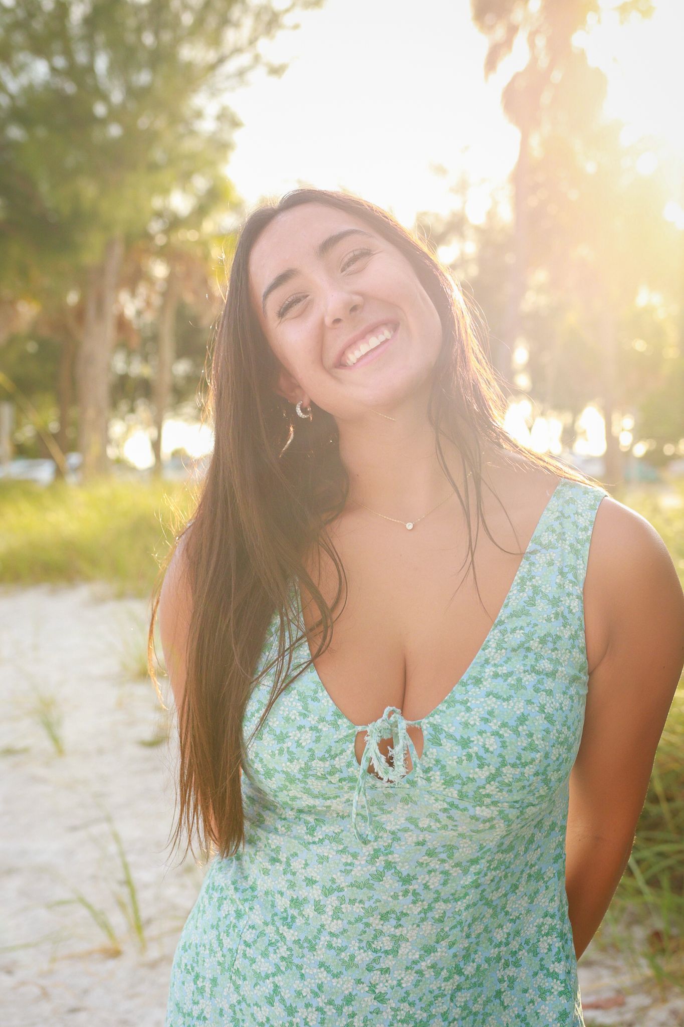 A girl dancing and smiling for the camera at sunset