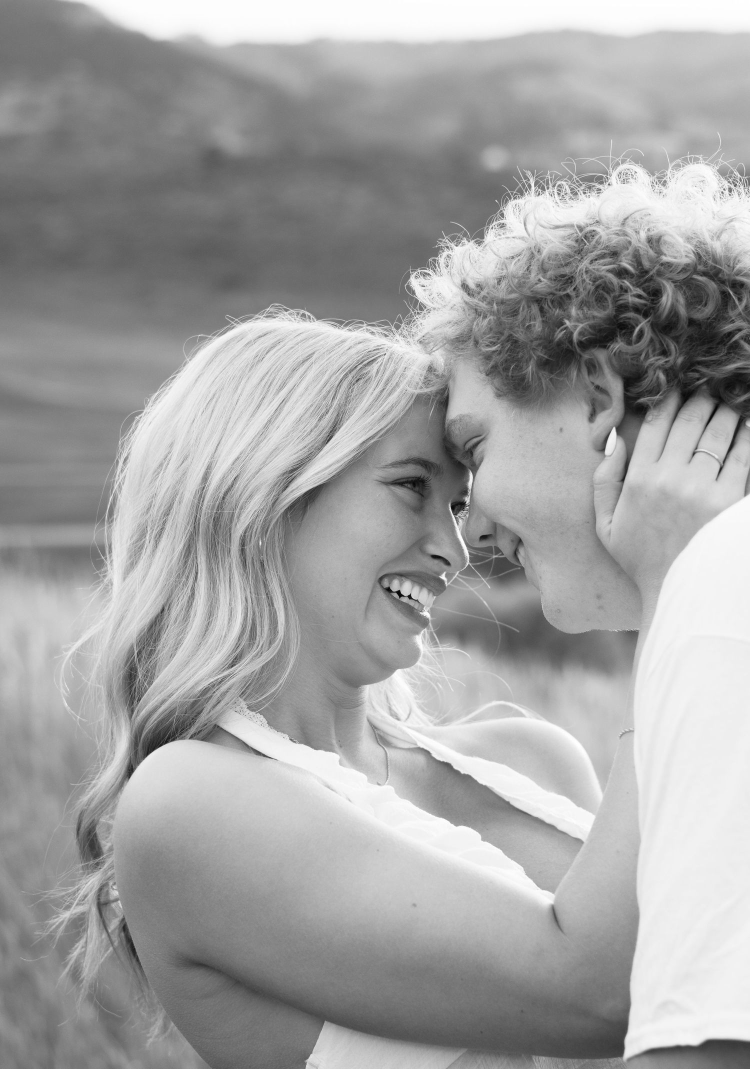 Intimate black and white portrait capturing a romantic moment outdoors.