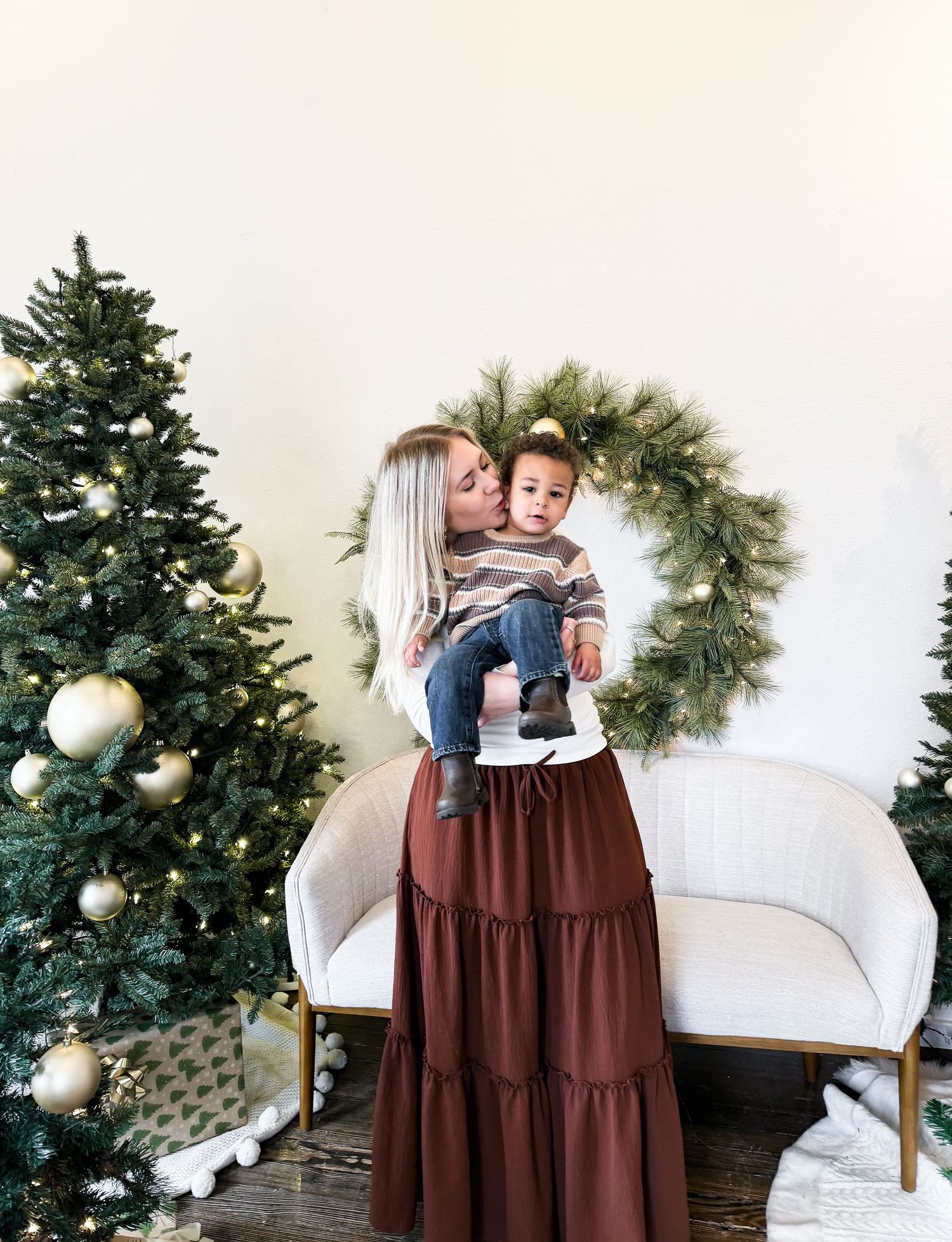 Holiday scene with decorated Christmas tree and wreath in modern interior.