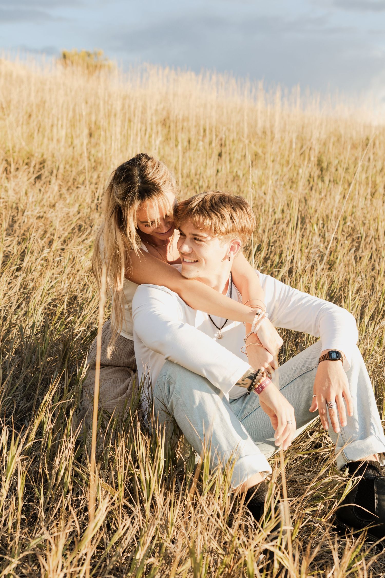 A tender embrace in a golden wheat field during sunset.