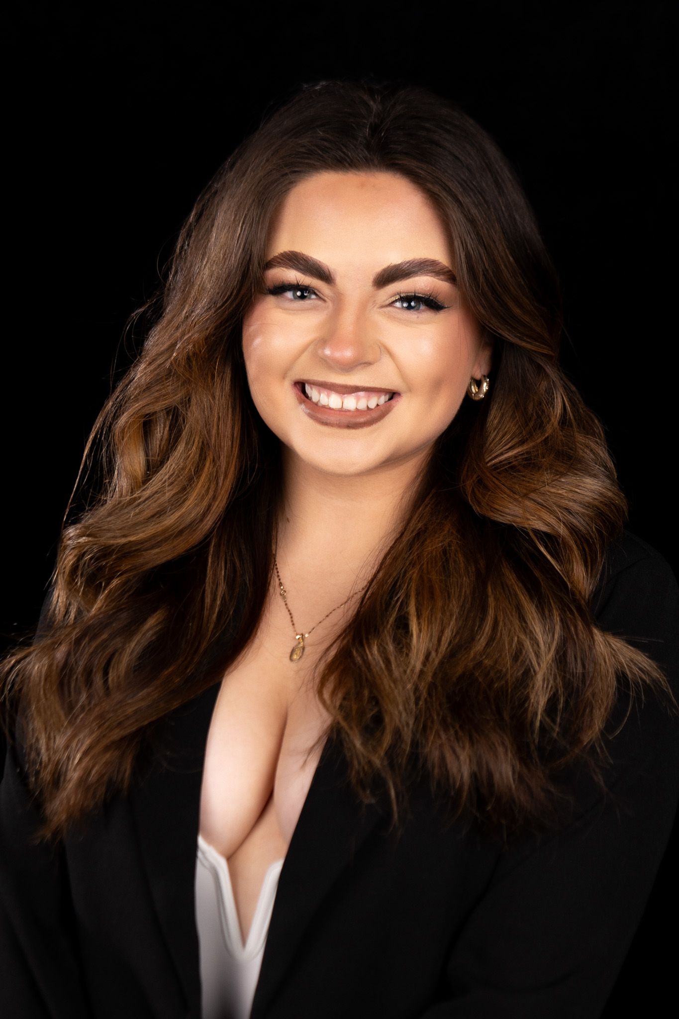 Professional portrait series featuring a person with flowing brown hair wearing a black blazer against dark background.