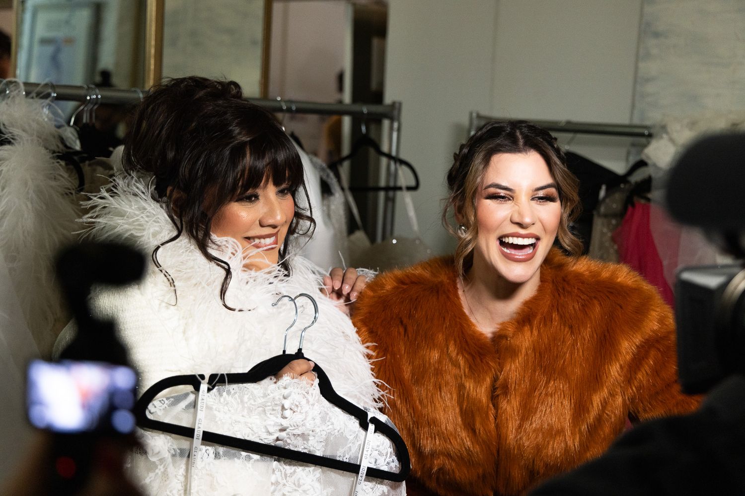 Behind-the-scenes photography showing styling preparations with white garments and brown fur accessories.