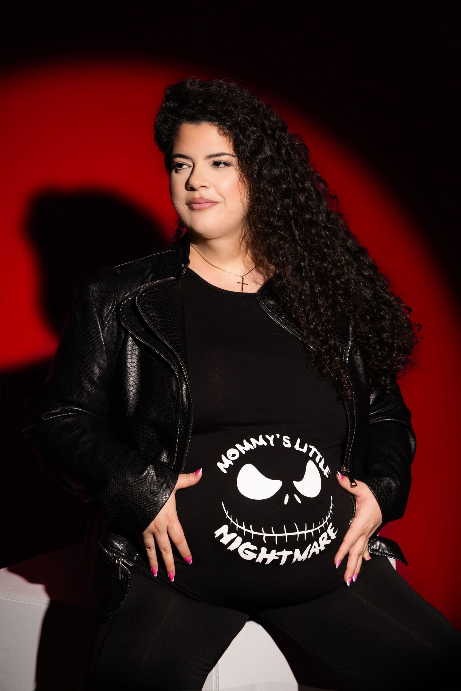 Portrait series showing a person in a black Jack Skellington t-shirt and leather jacket against a red and black background.