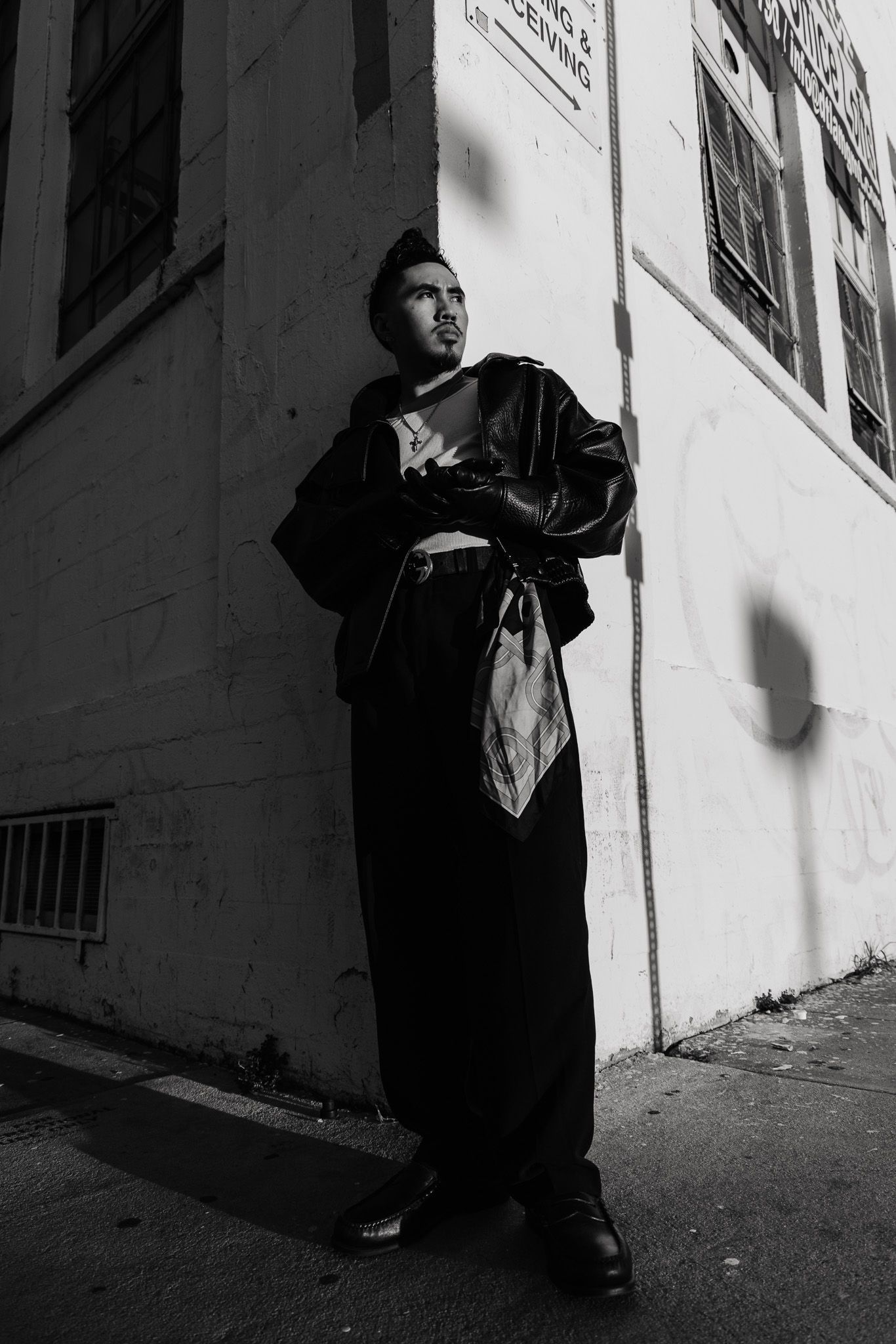 A dramatic black and white photo sequence shows a figure in dark clothing moving through shadows against white walls.