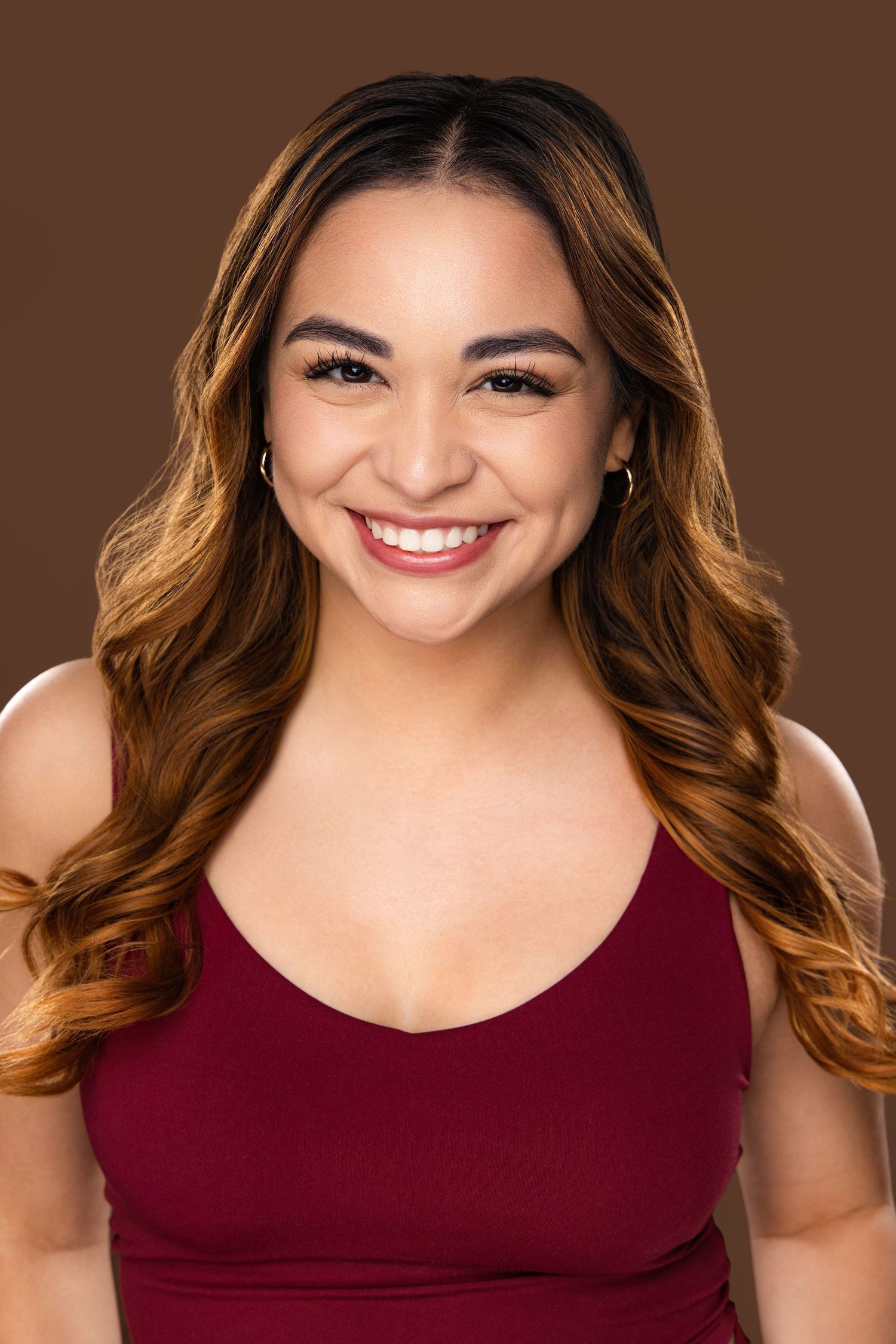 Portrait series showing a person in a burgundy sleeveless top with wavy brown hair and bright smile against brown backdrop.