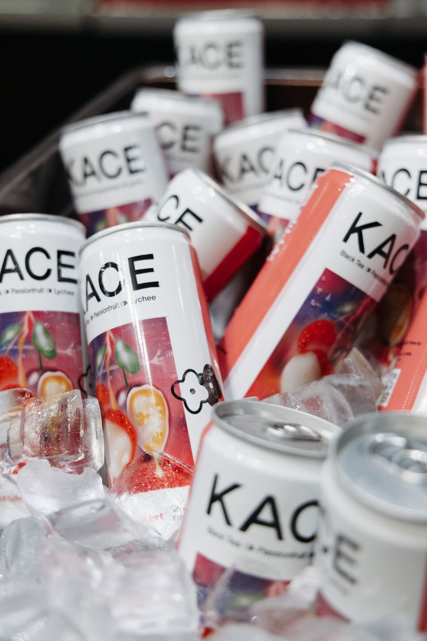 Cans of KACE beverages chilling on ice at an event display.