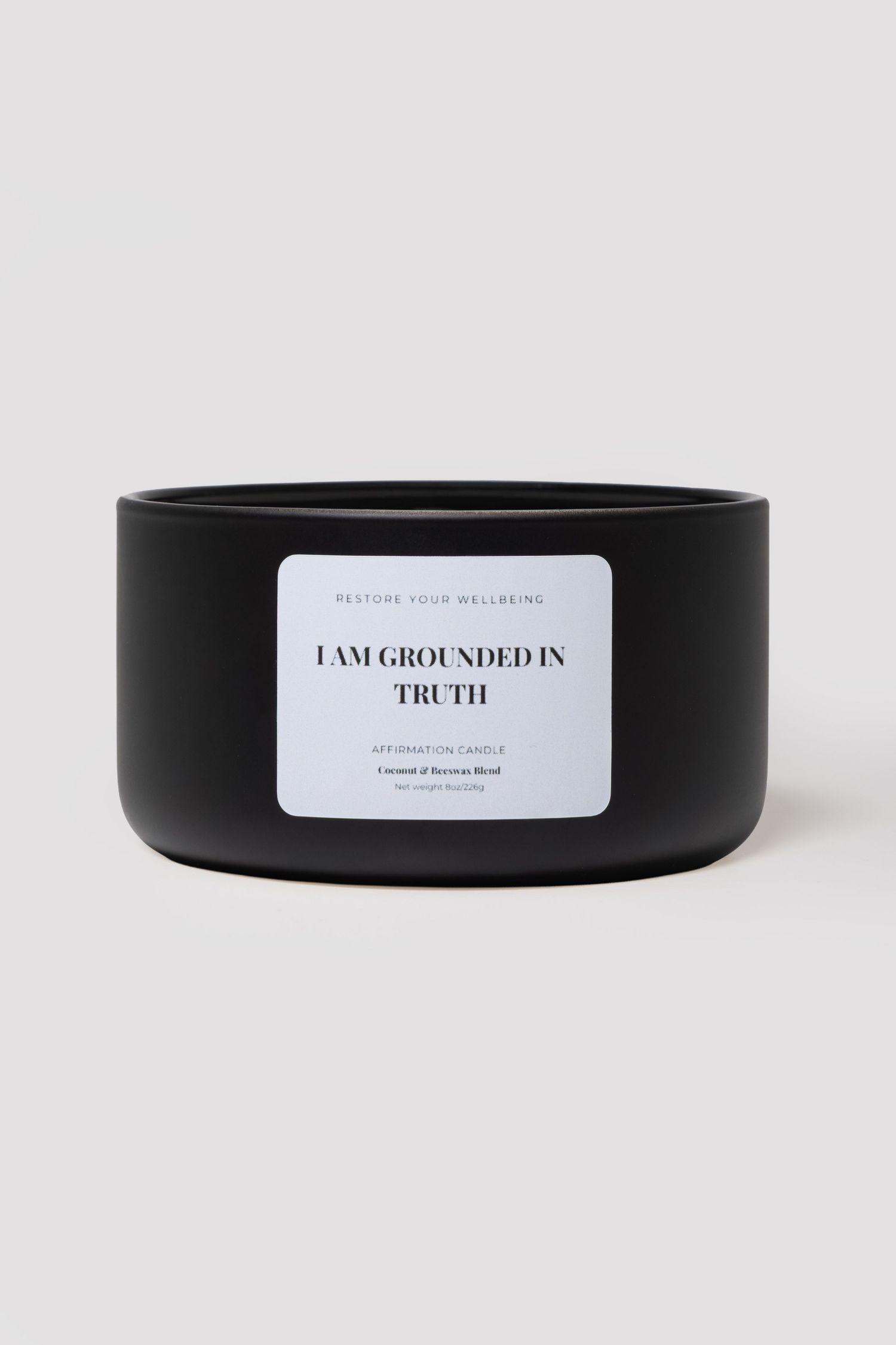 Black matte ceramic candle bowl labeled 'I Am Grounded In Truth' Coconut & Beeswax Blend intention candle.