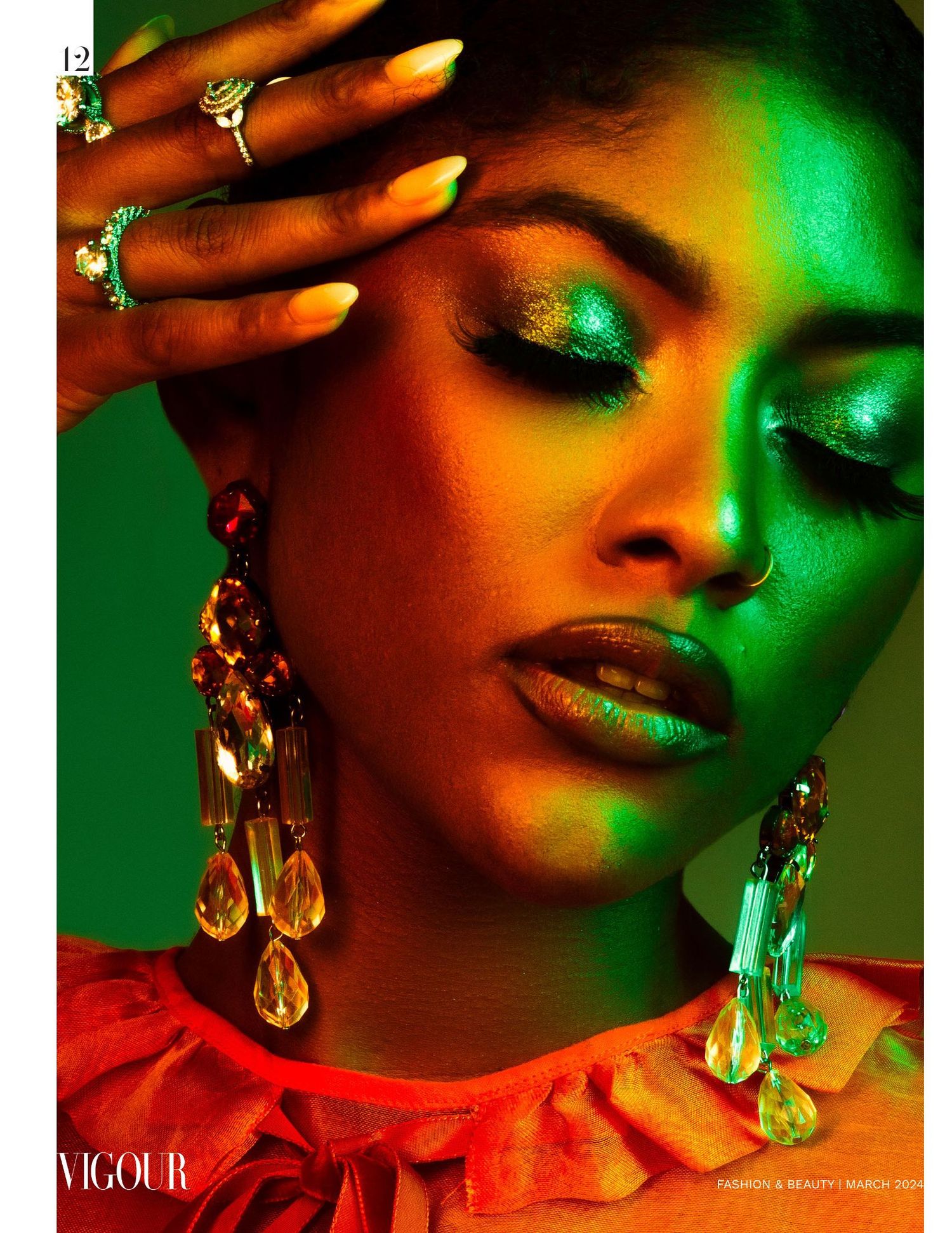 Fashion beauty portrait with dramatic red and green lighting featuring crystal earrings and glowing metallic makeup.