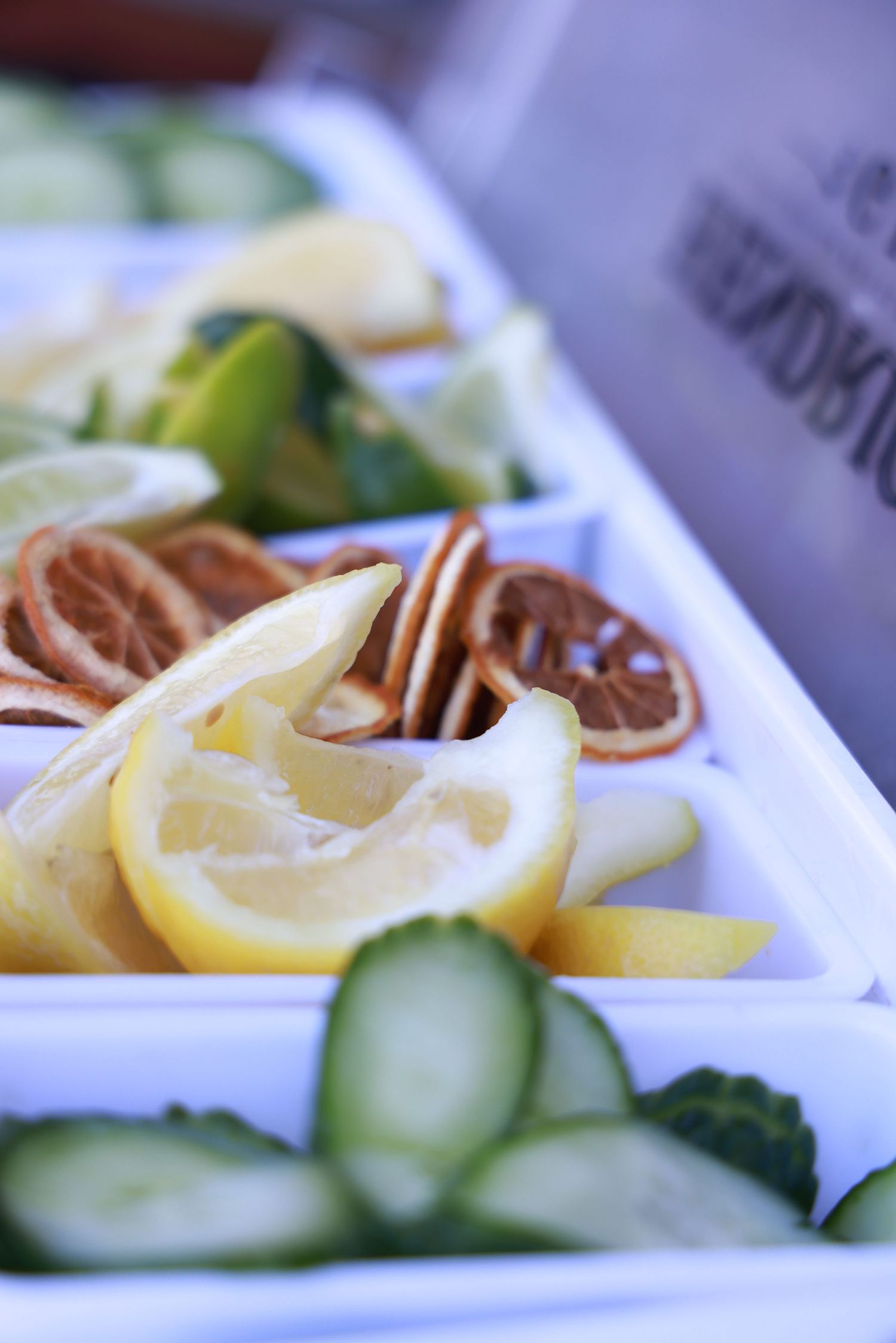 Fresh lemon slices and cucumber garnishes arranged on white plates with decorative elements.